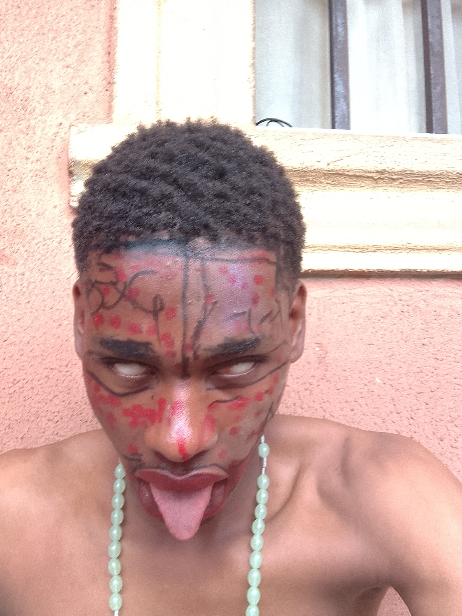 Young person photographed wearing elaborate red and black face paint