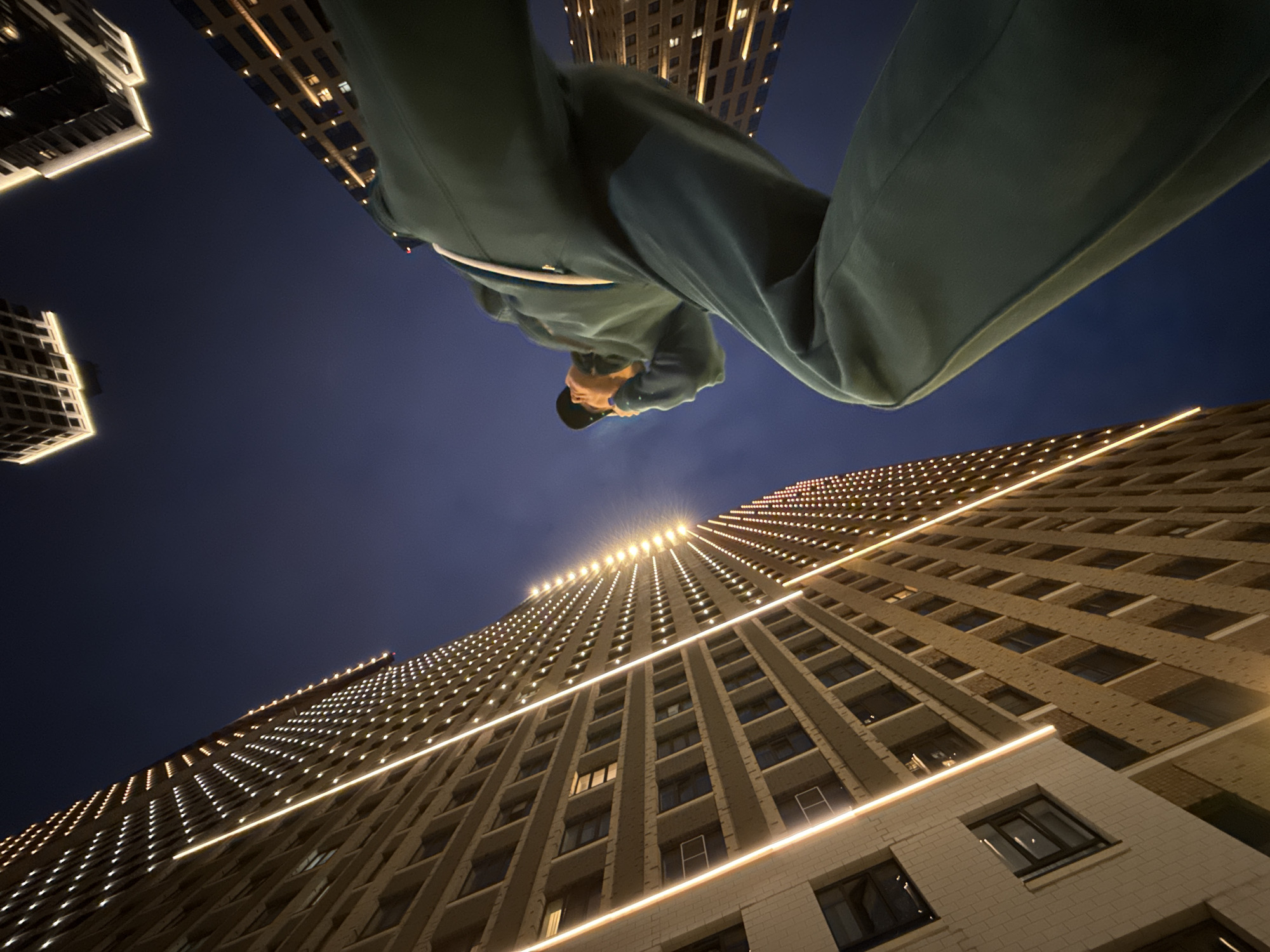 Teal tracksuit, phone in hand, looking up in Moscow