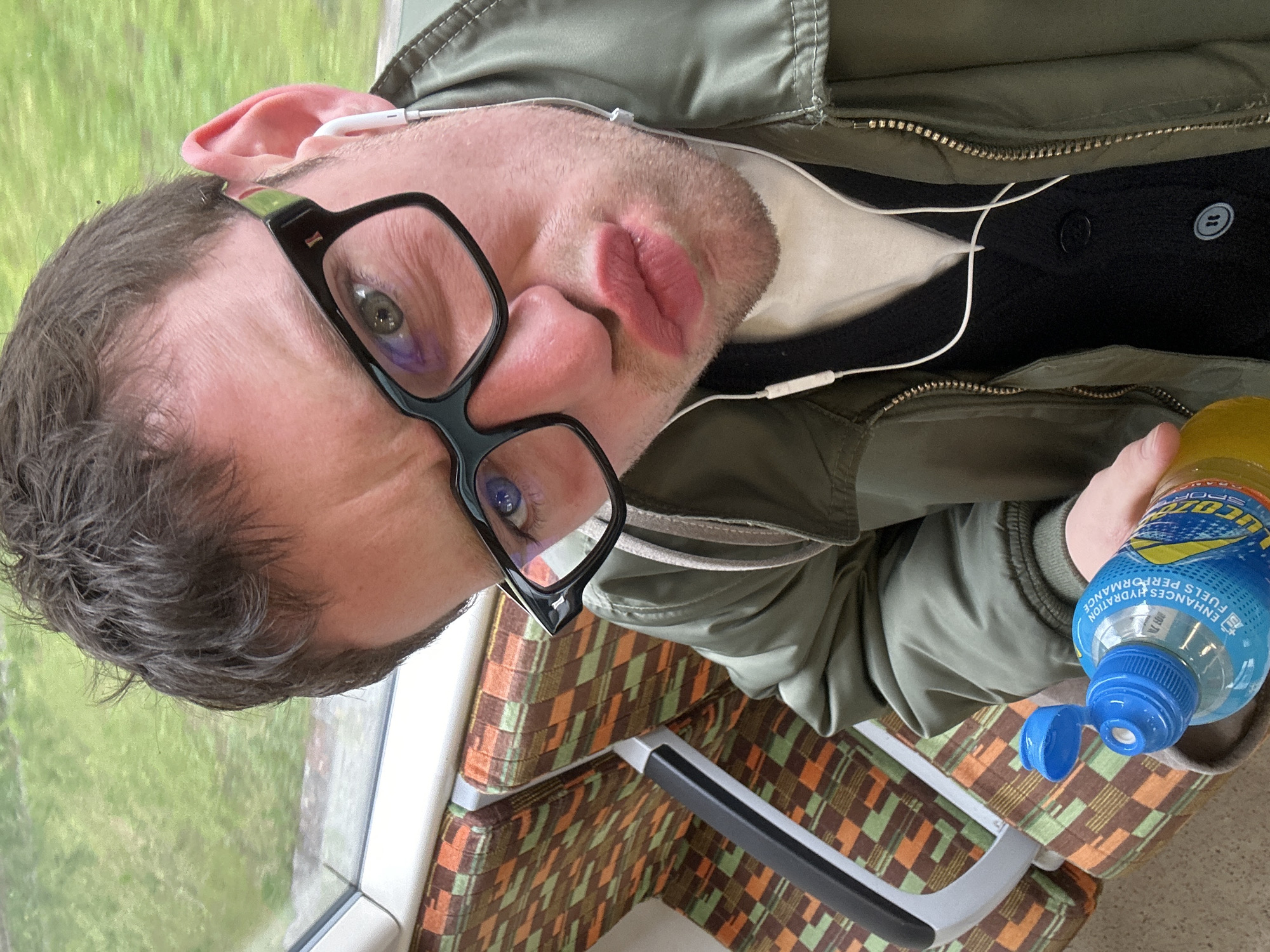London train passenger drinks Lucozade during morning commute