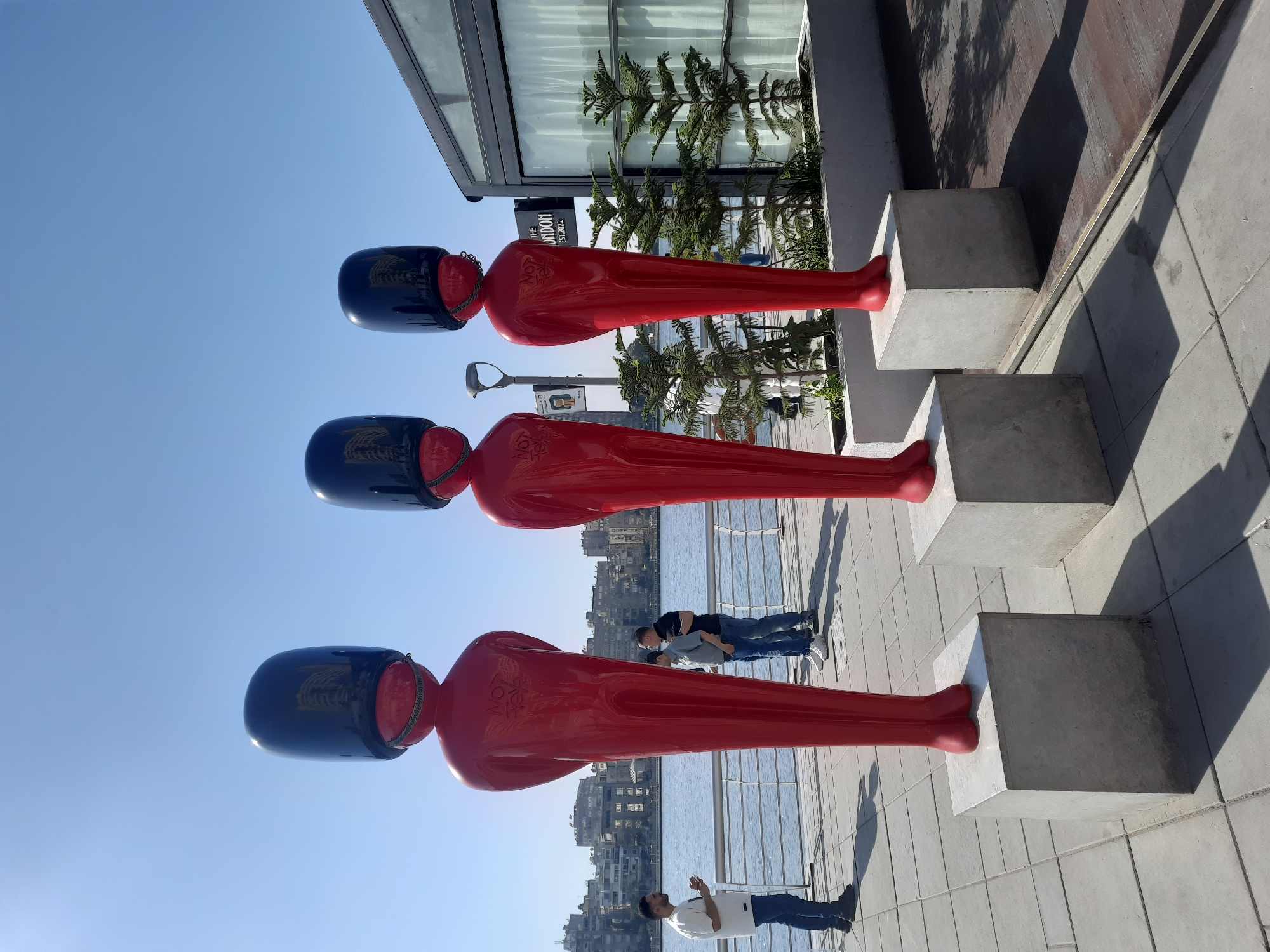 Red humanoid sculptures displayed along Cairo waterfront walkway