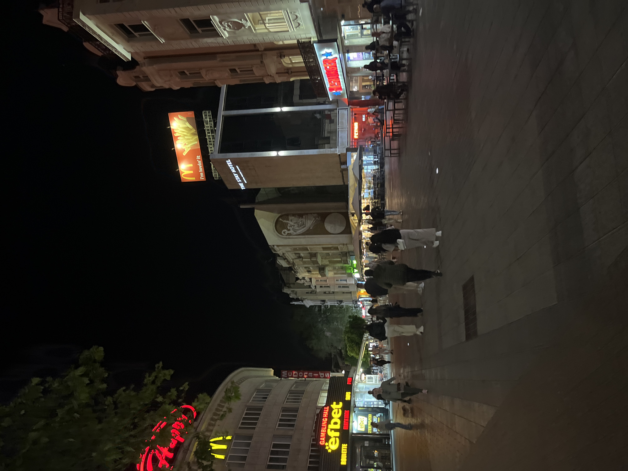 Evening pedestrians stroll central Plovdiv streets near commercial district
