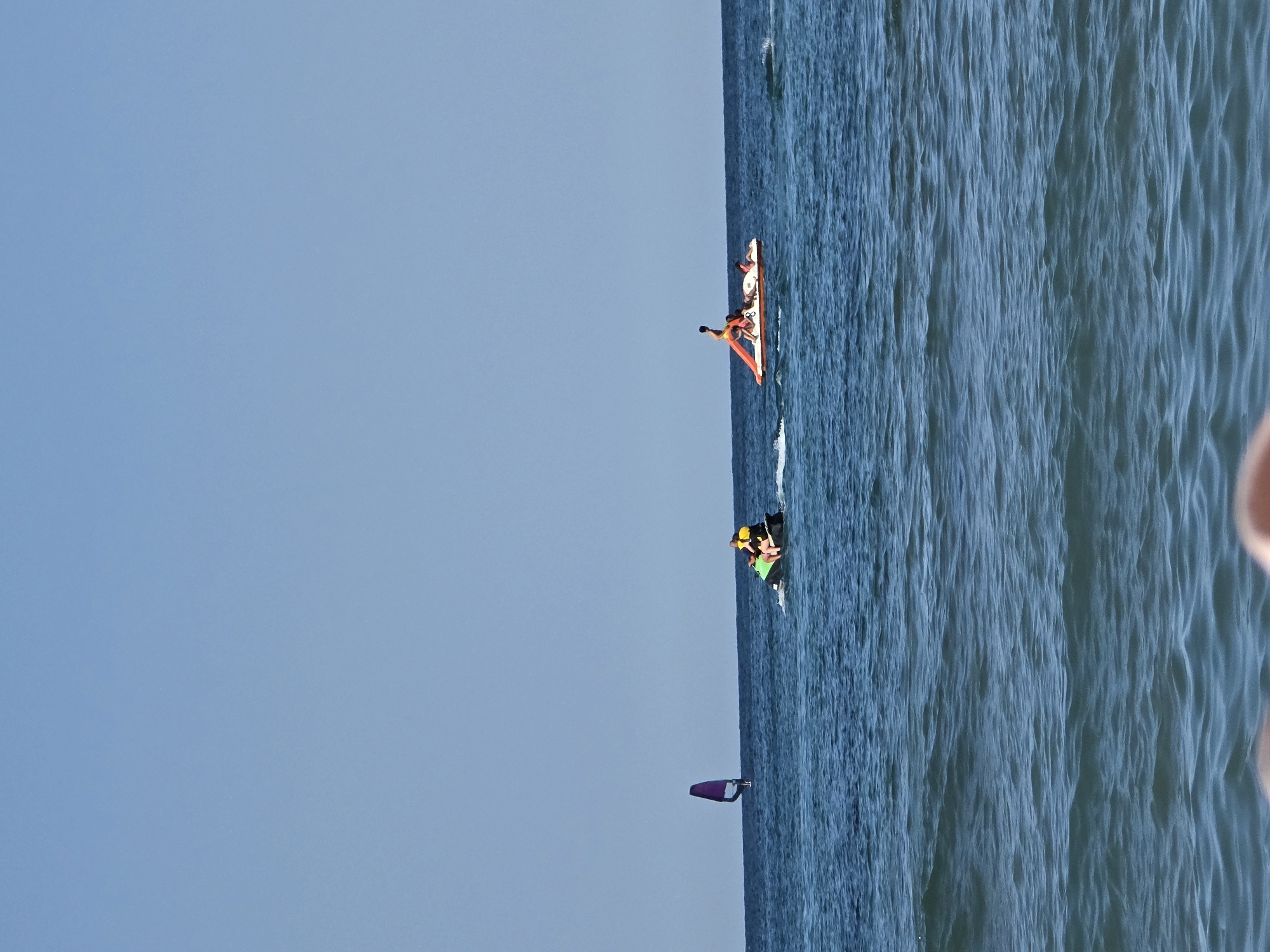 Busy ocean day: paddleboarding, swimming, and watersports in full swing