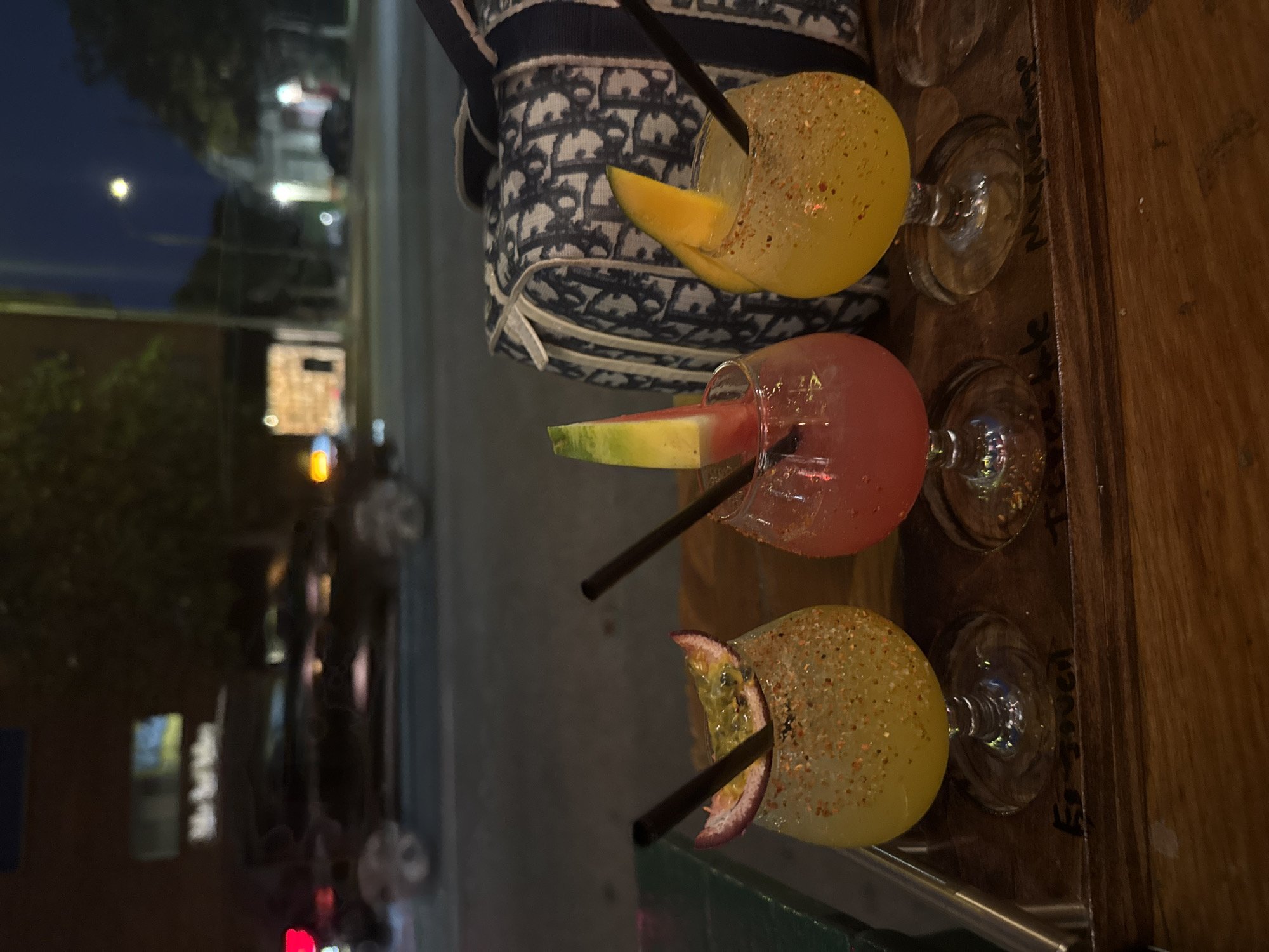 Three garnished cocktails spotted on wooden surface in Los Angeles