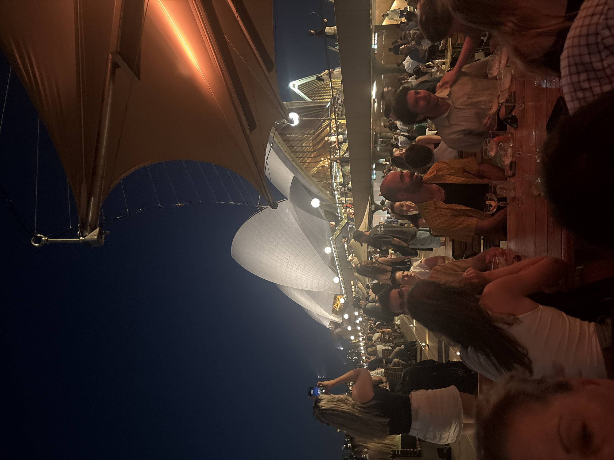 Evening diners gather near Sydney Opera House and Harbour Bridge