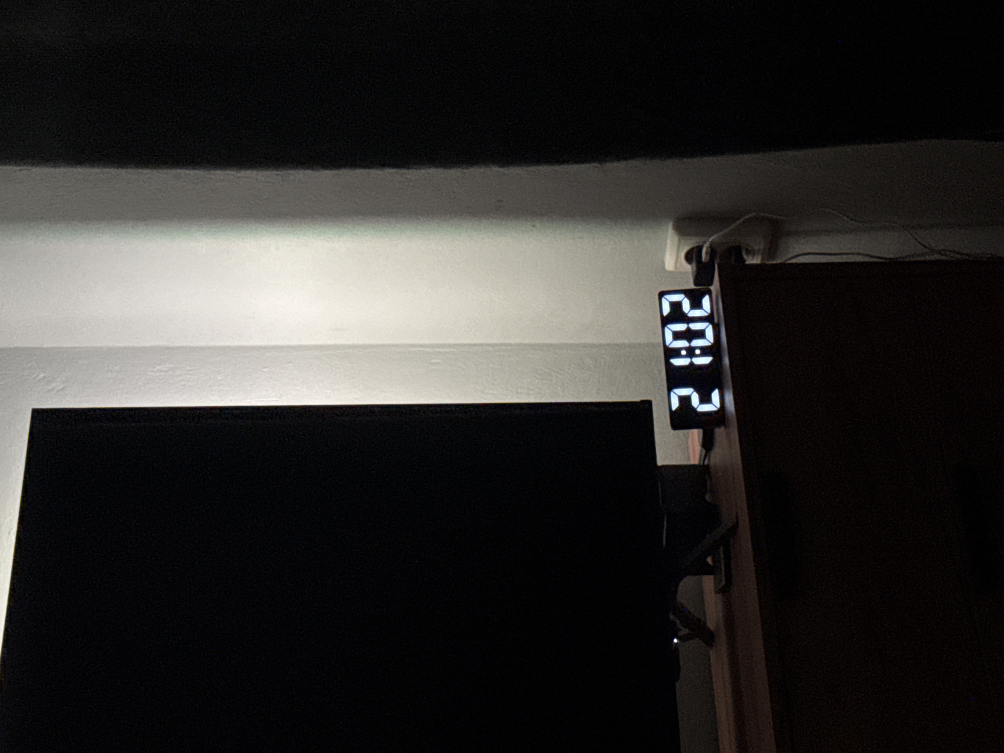 Digital clock shows 9:02 PM in dimly lit room