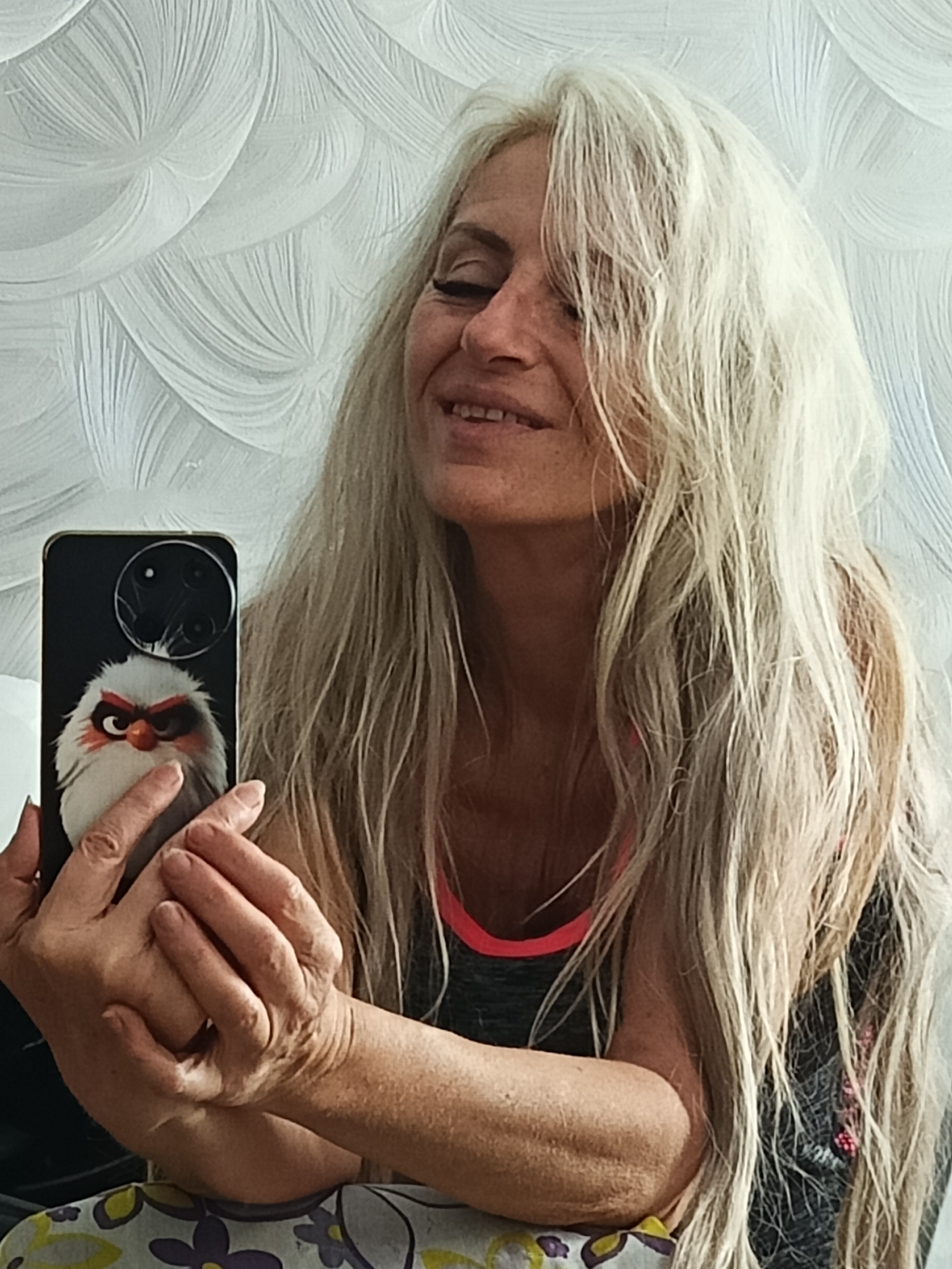 Woman takes multiple selfies with smartphone in Belarus home