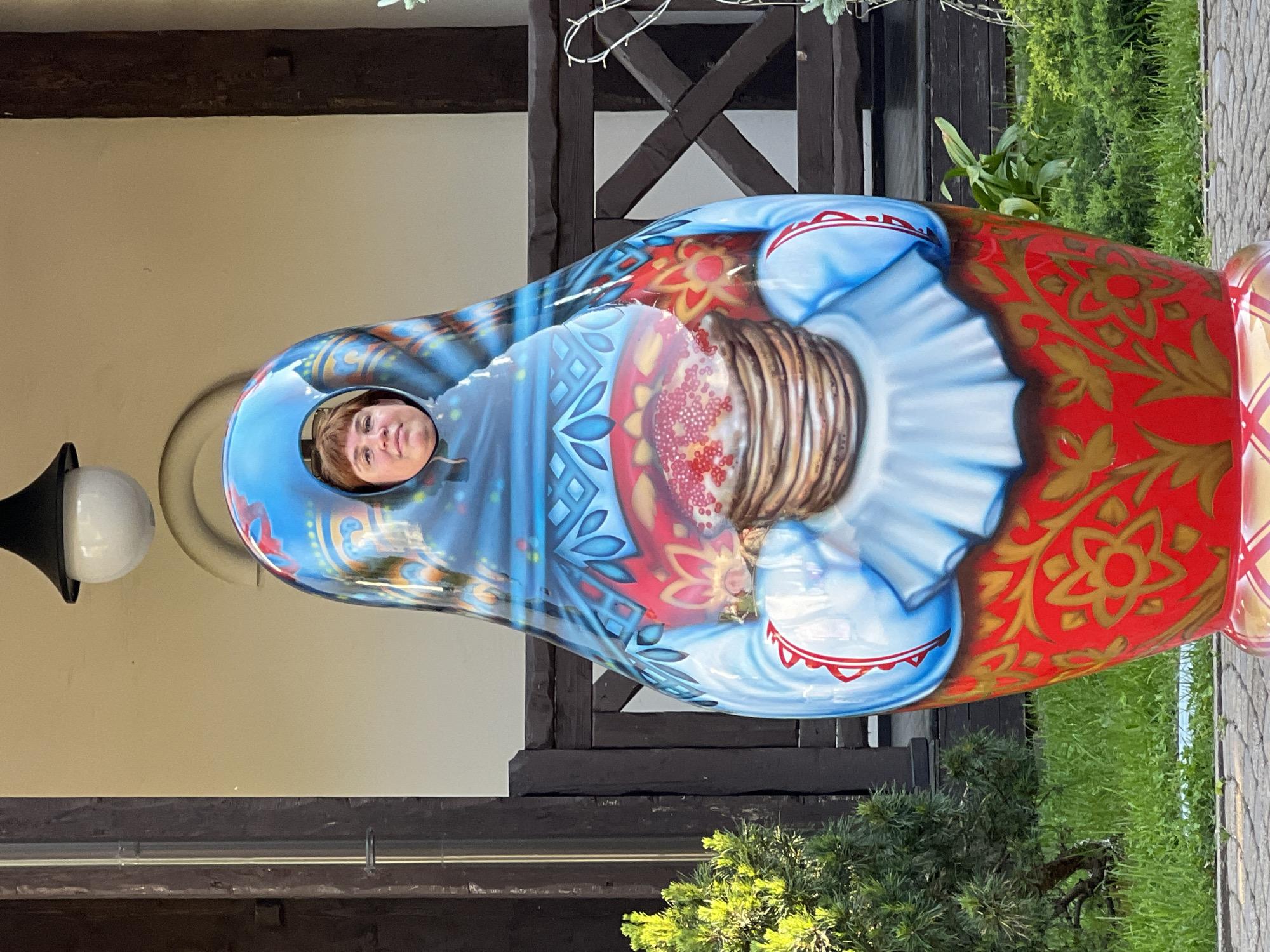 Tourist visits Russian cultural site, poses with matryoshka prop