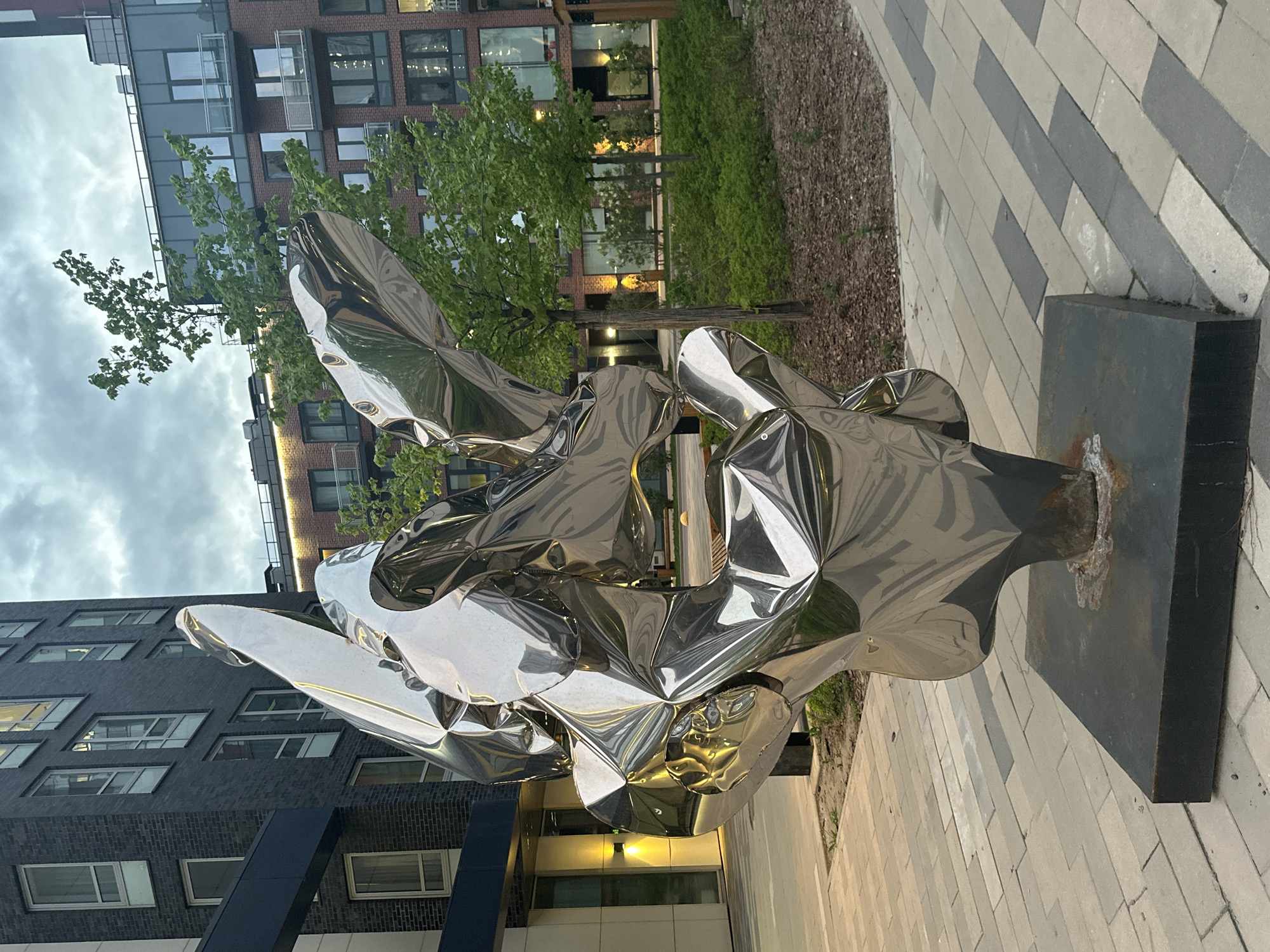 Reflective metallic sculpture spotted on urban brick walkway