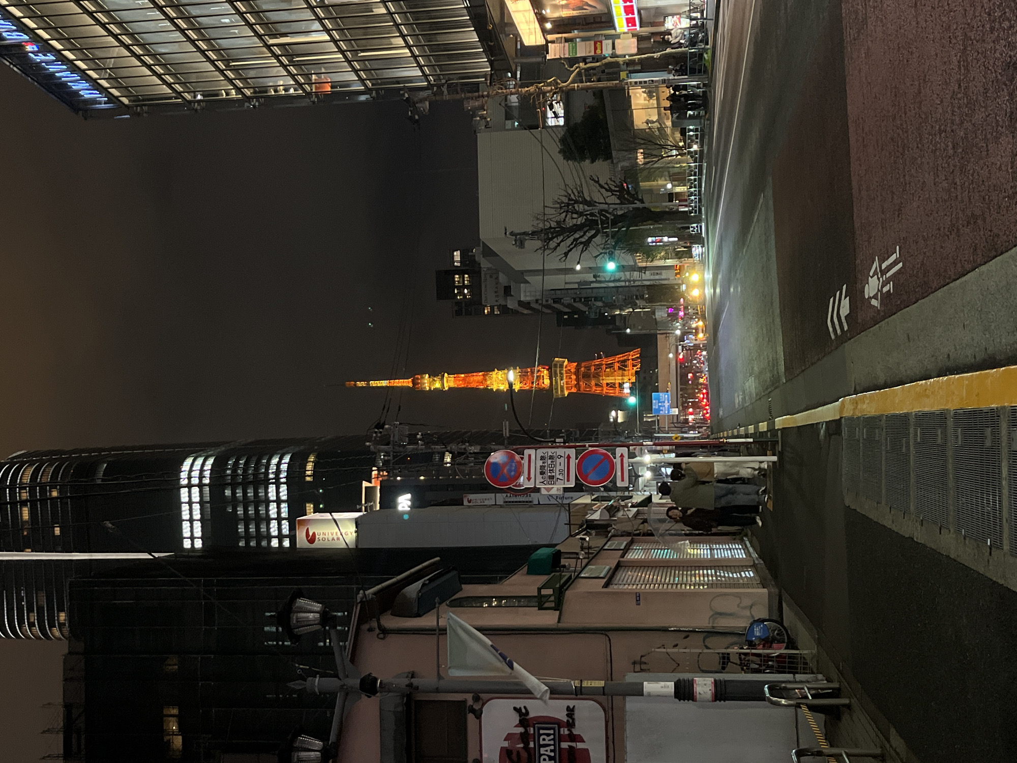 Tokyo Tower glows orange in nighttime Minato City scene
