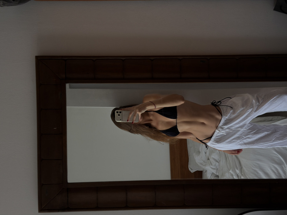 Woman takes mirror selfie in bikini top in Tibubeneng