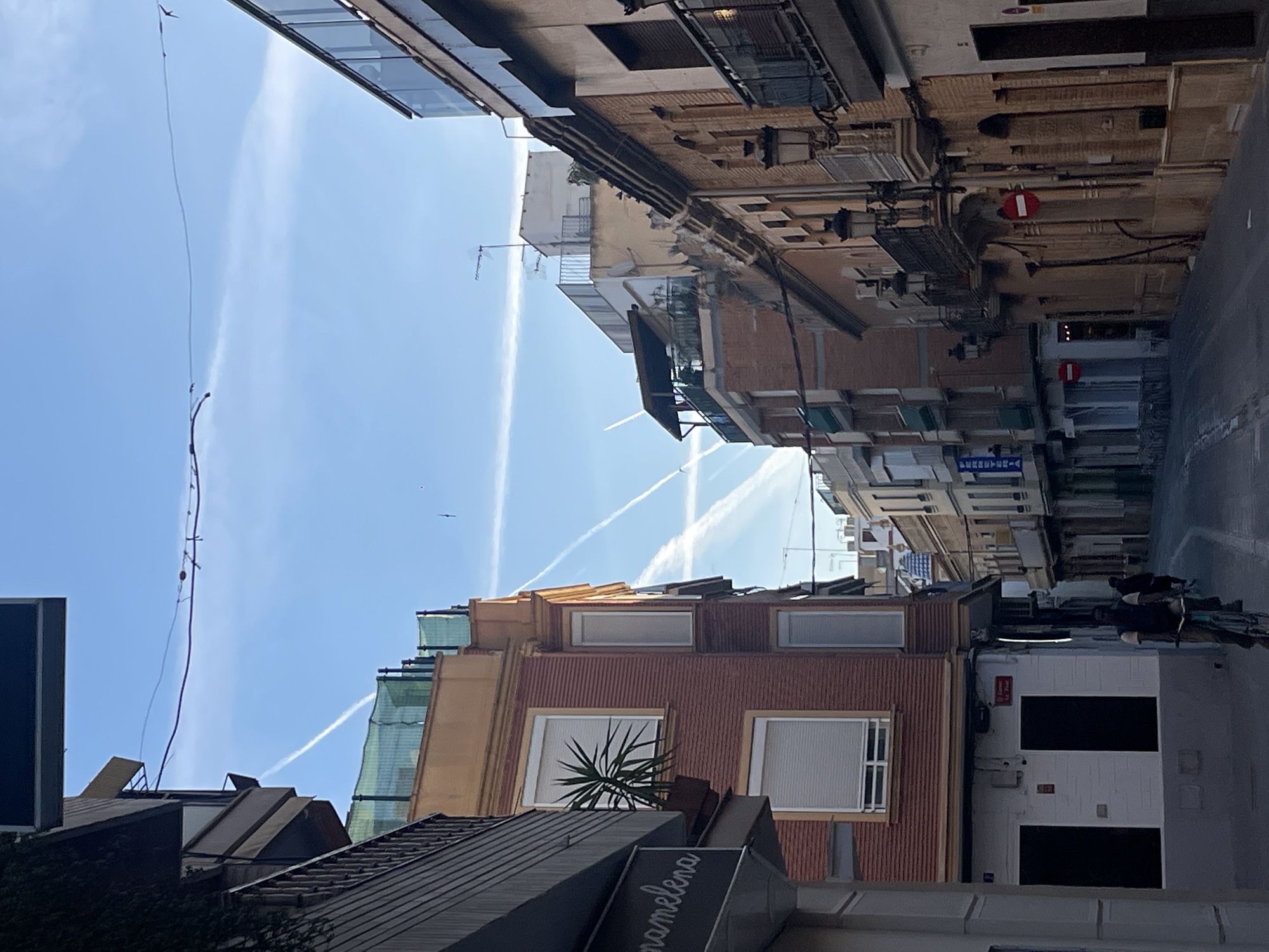 Aircraft contrails streak across morning skies over Paiporta, Spain