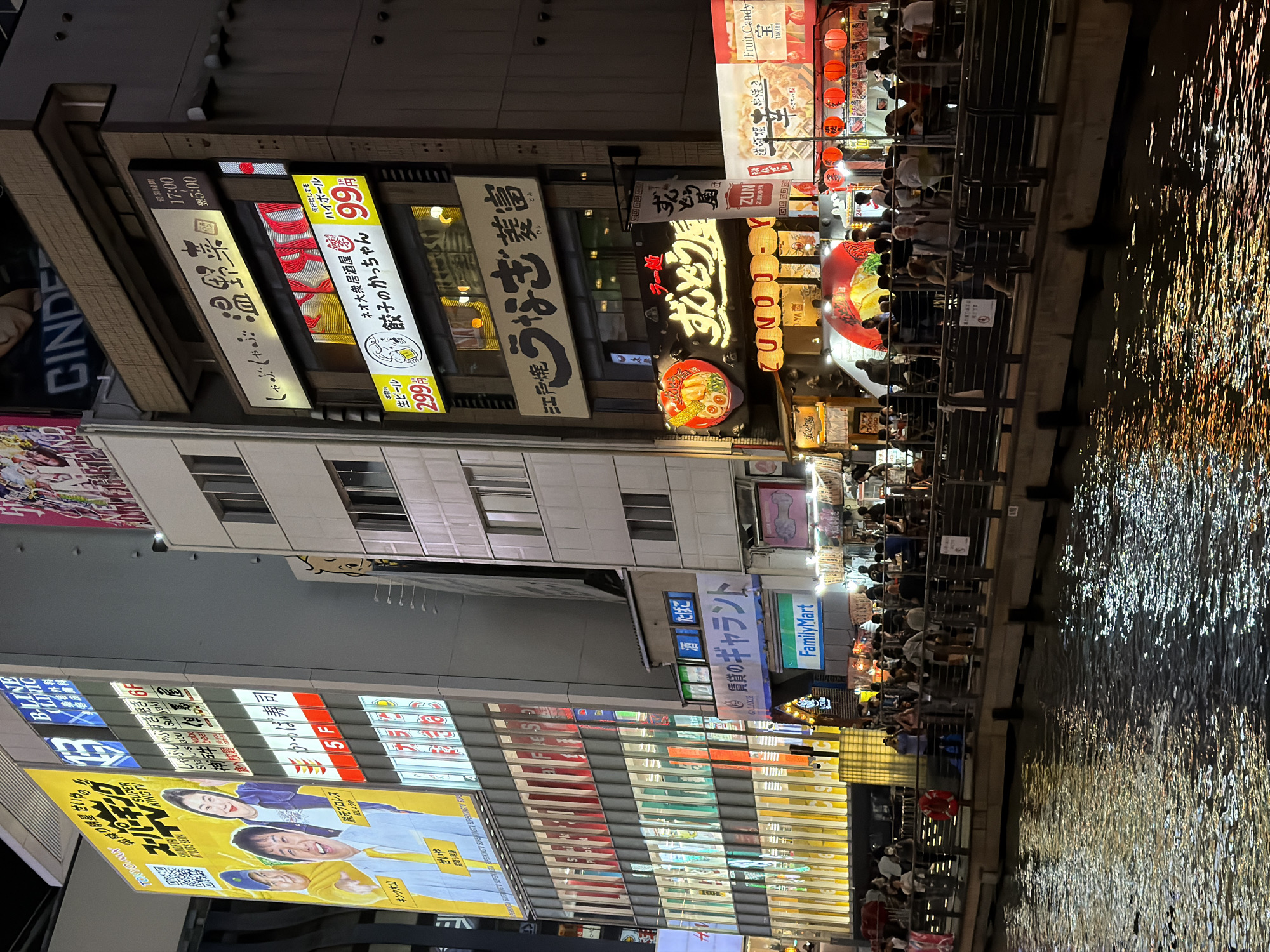 Neon-lit Osaka canal district bustling with nighttime activity