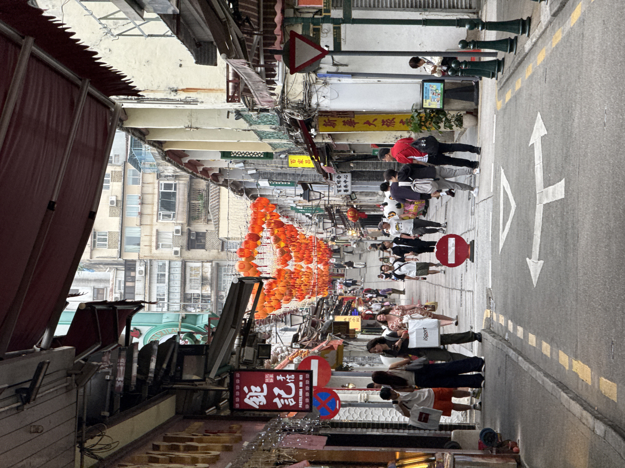 Morning crowds fill narrow Macau street amid mixed architecture
