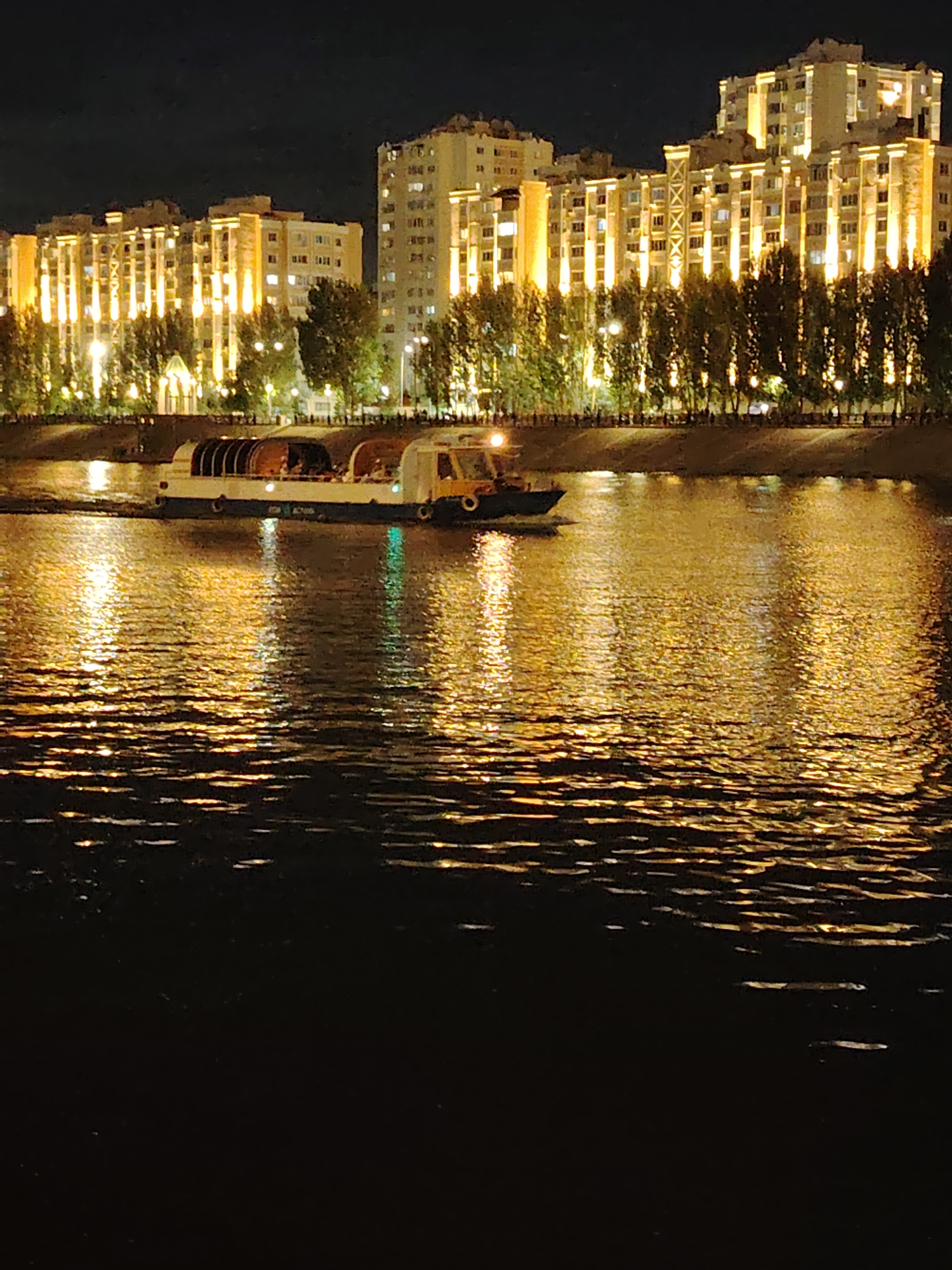 Astana's Ishim riverfront lit up on a summer night