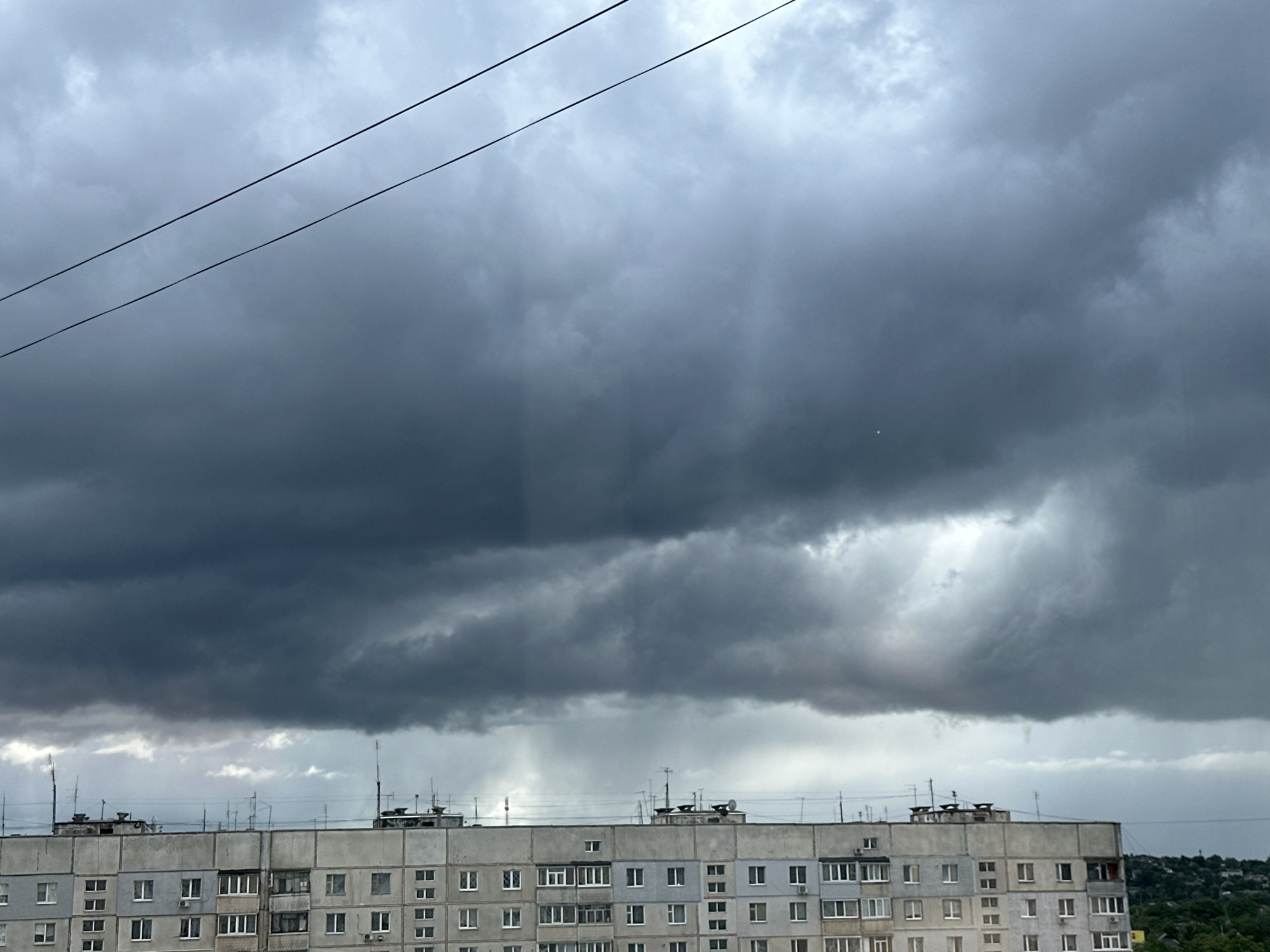 Storm clouds gather over urban area with street life