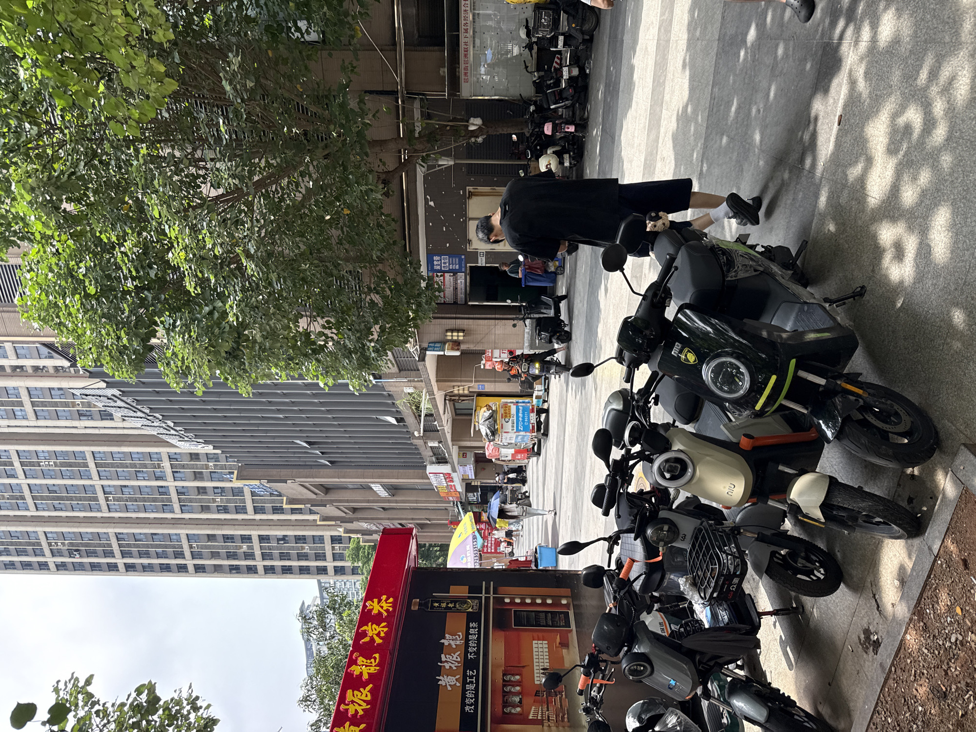 Haizhu District street buzzing with scooters, scaffolding, and foot traffic