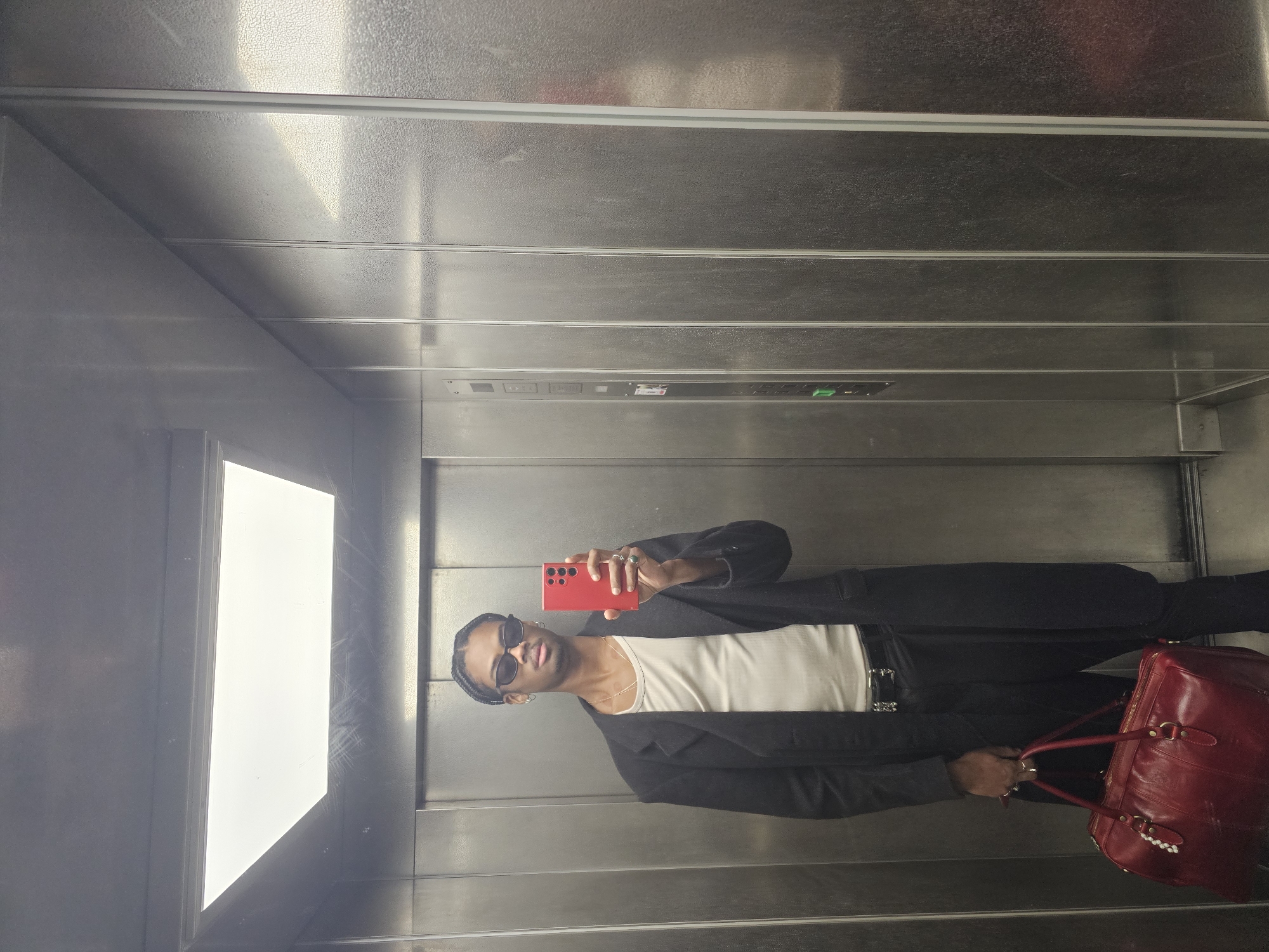 Person with red phone moves through Pantin elevator, streets