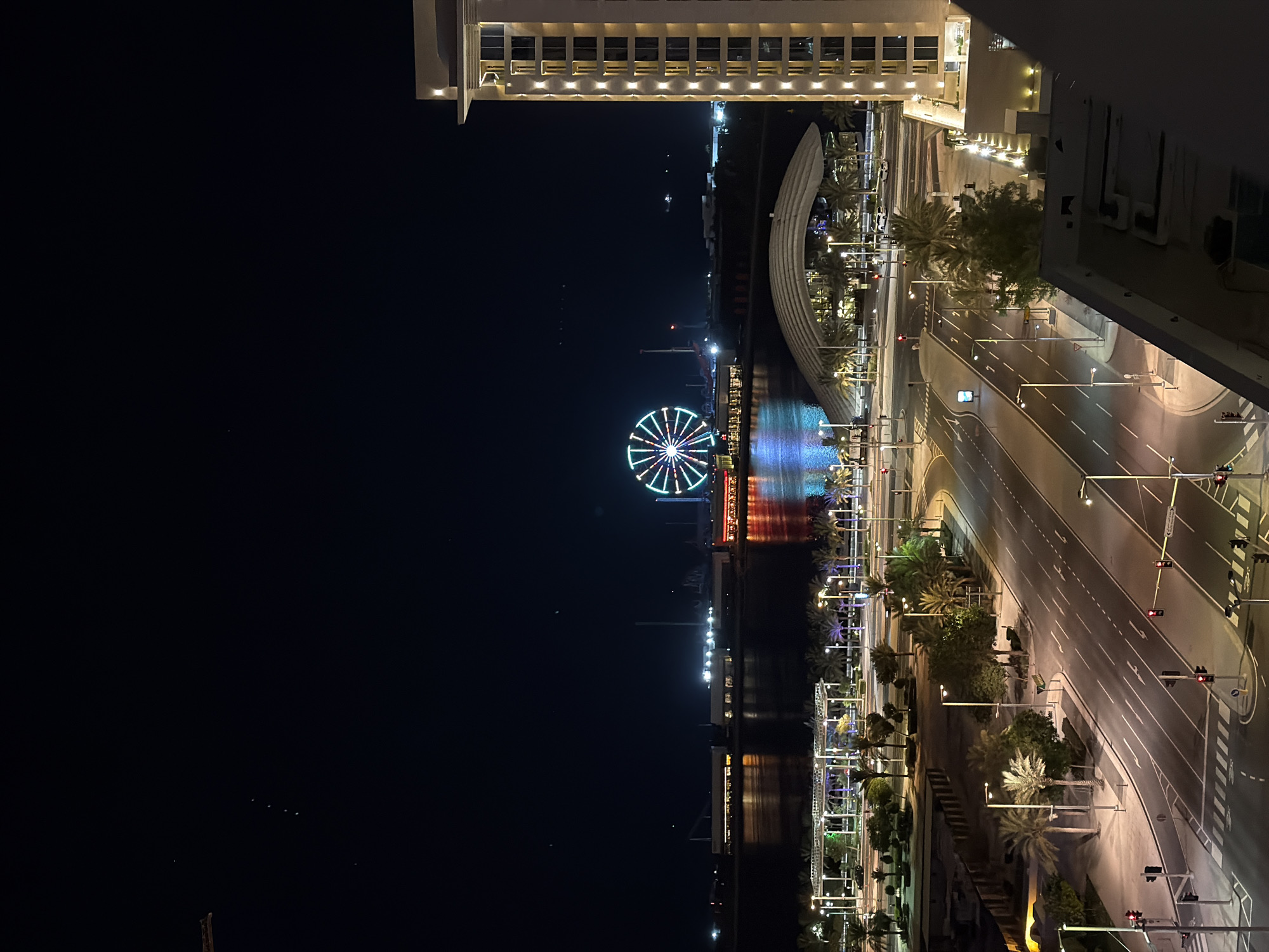 Colorful Ferris wheel lights over Lusail's waterfront at night