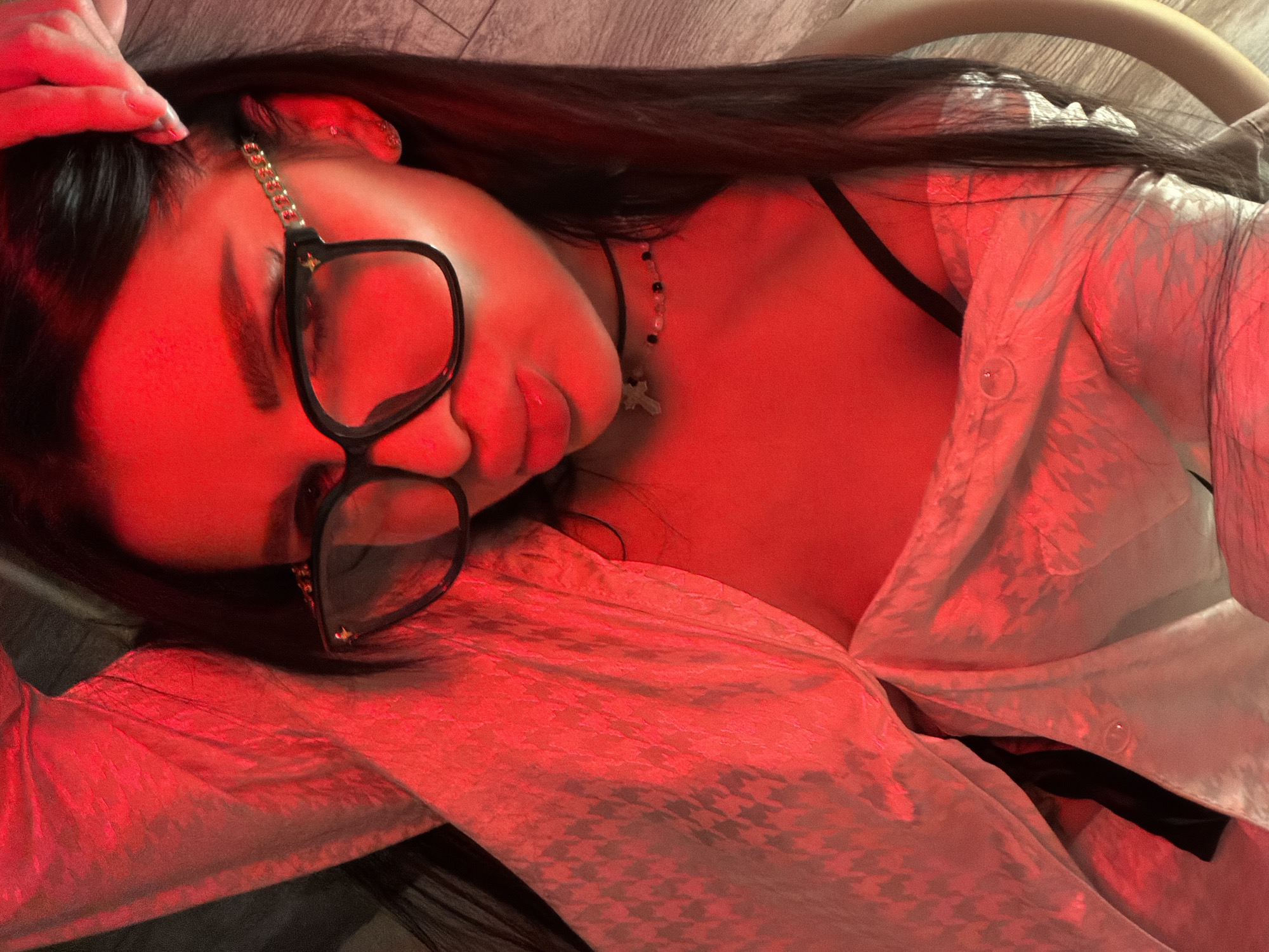Person resting indoors in Moscow wearing glasses and jewelry