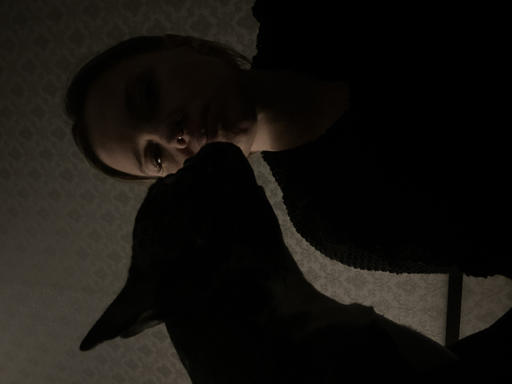 Woman with piercings shares moment with speckled dog