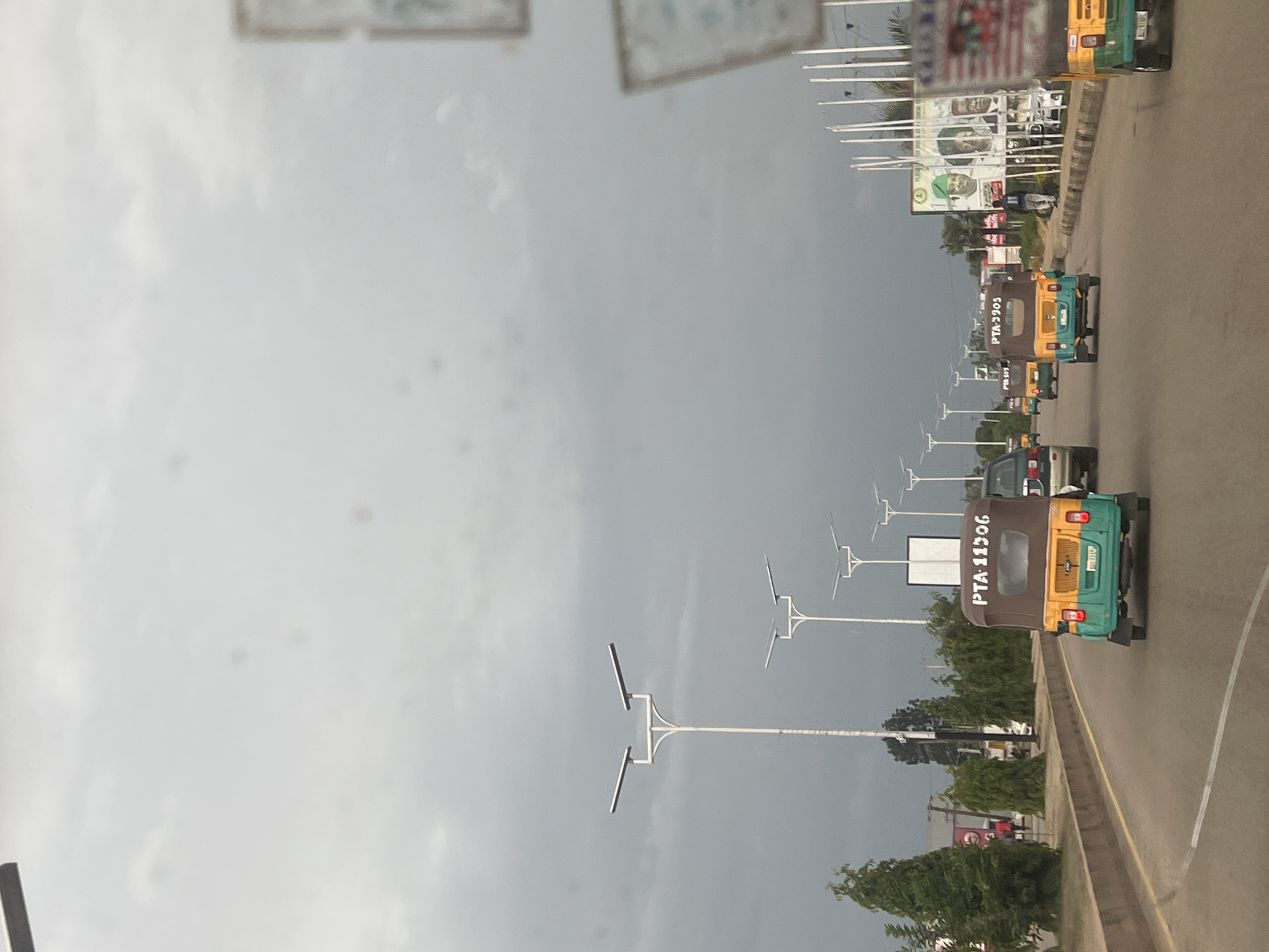 Street-level look at Jos roads, keke traffic, and infrastructure signage