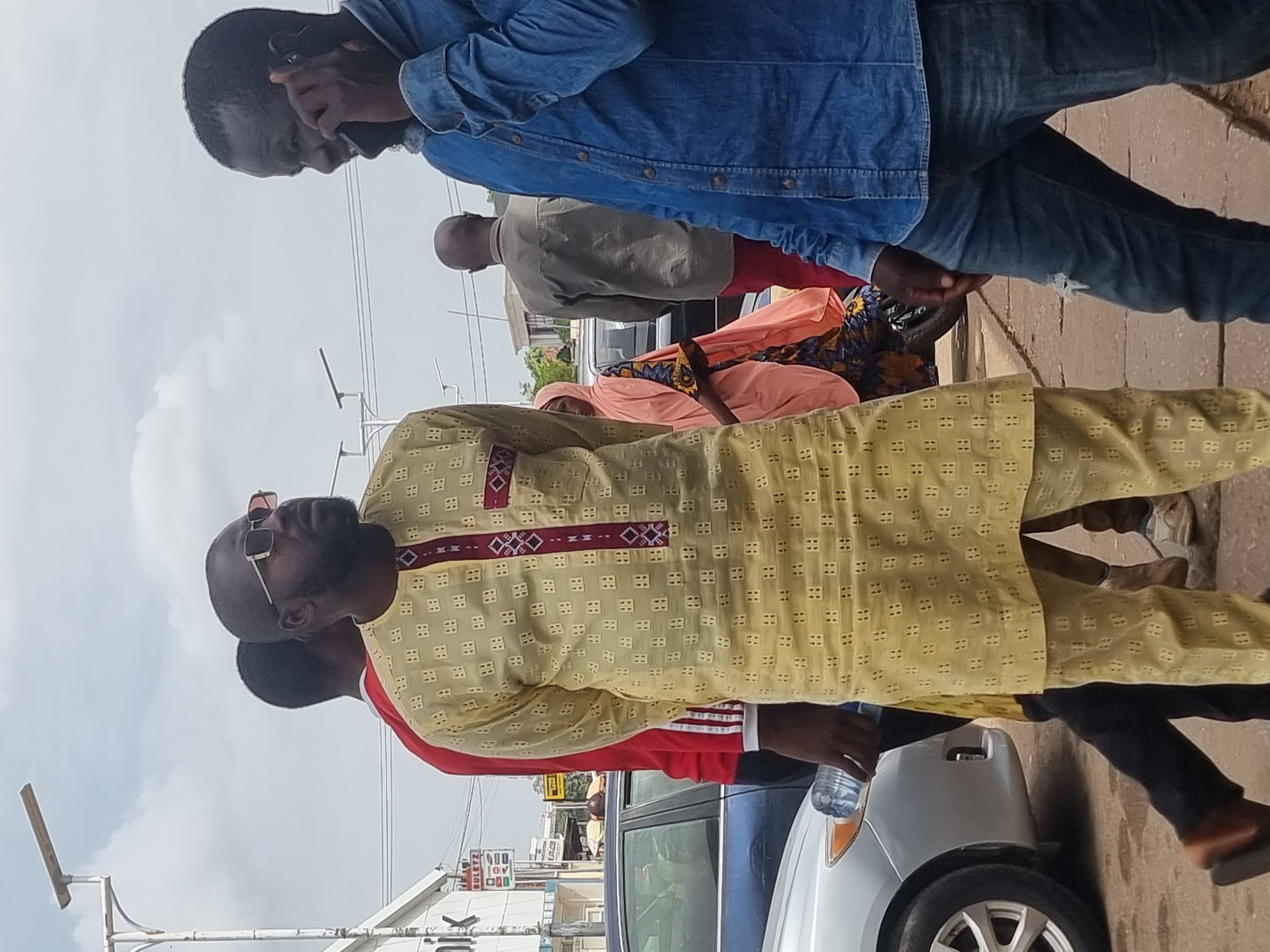 Man in yellow outfit observed on sidewalk near parked cars