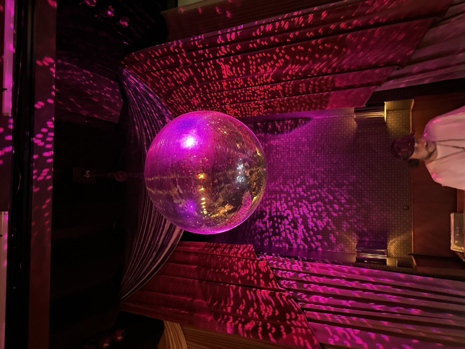 Disco ball casts pink light in dimly lit London venue