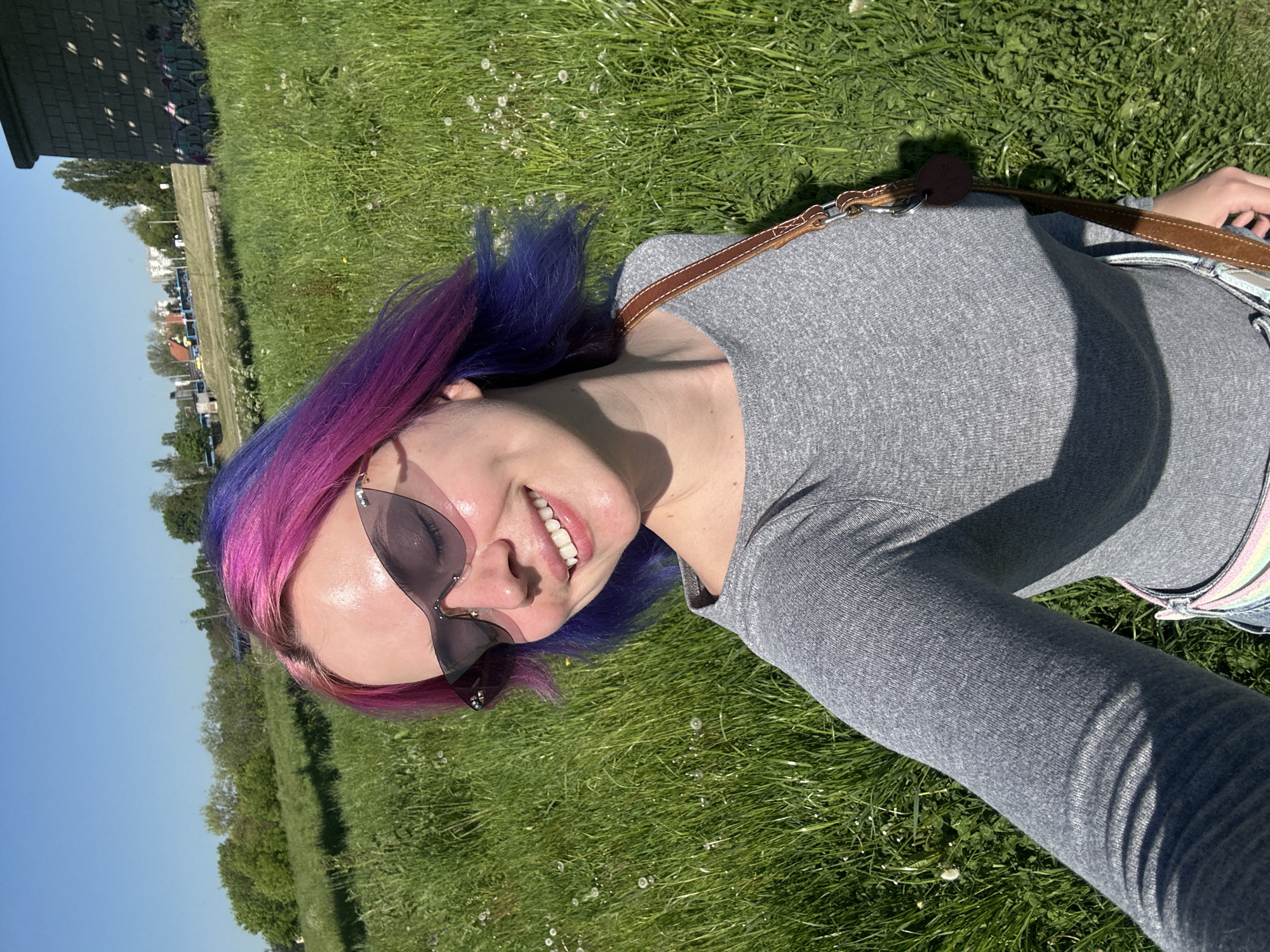 Woman with colorful hair rests in Zagreb field