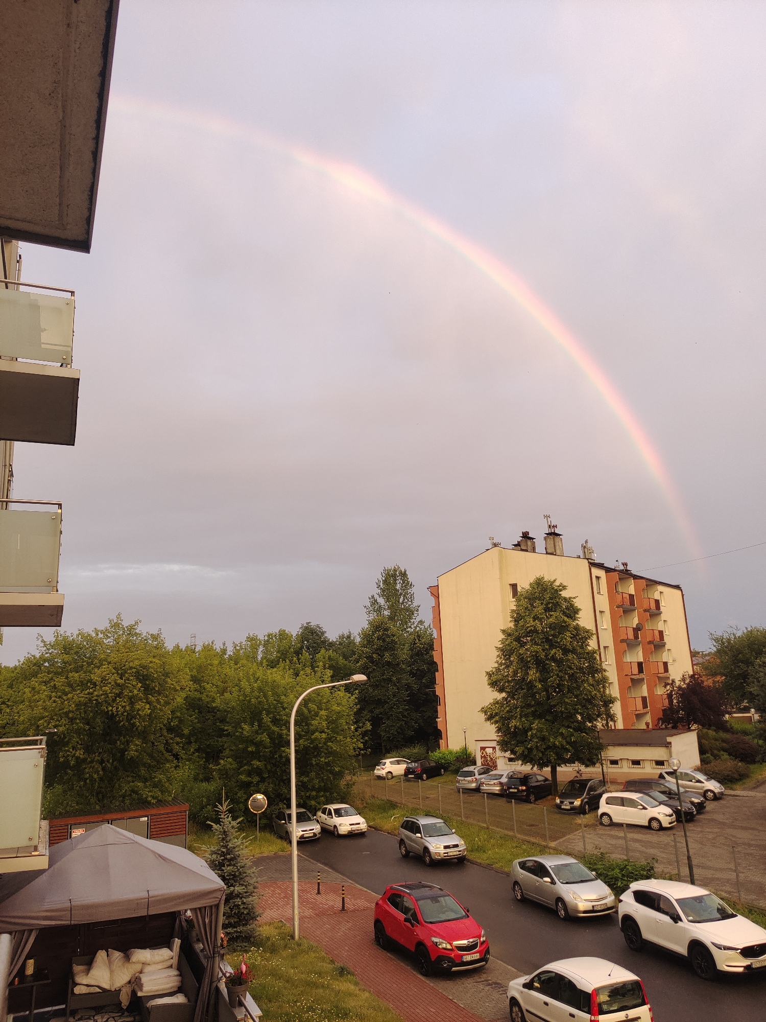 Rainbow spans Częstochowa skyline on a cloudy evening