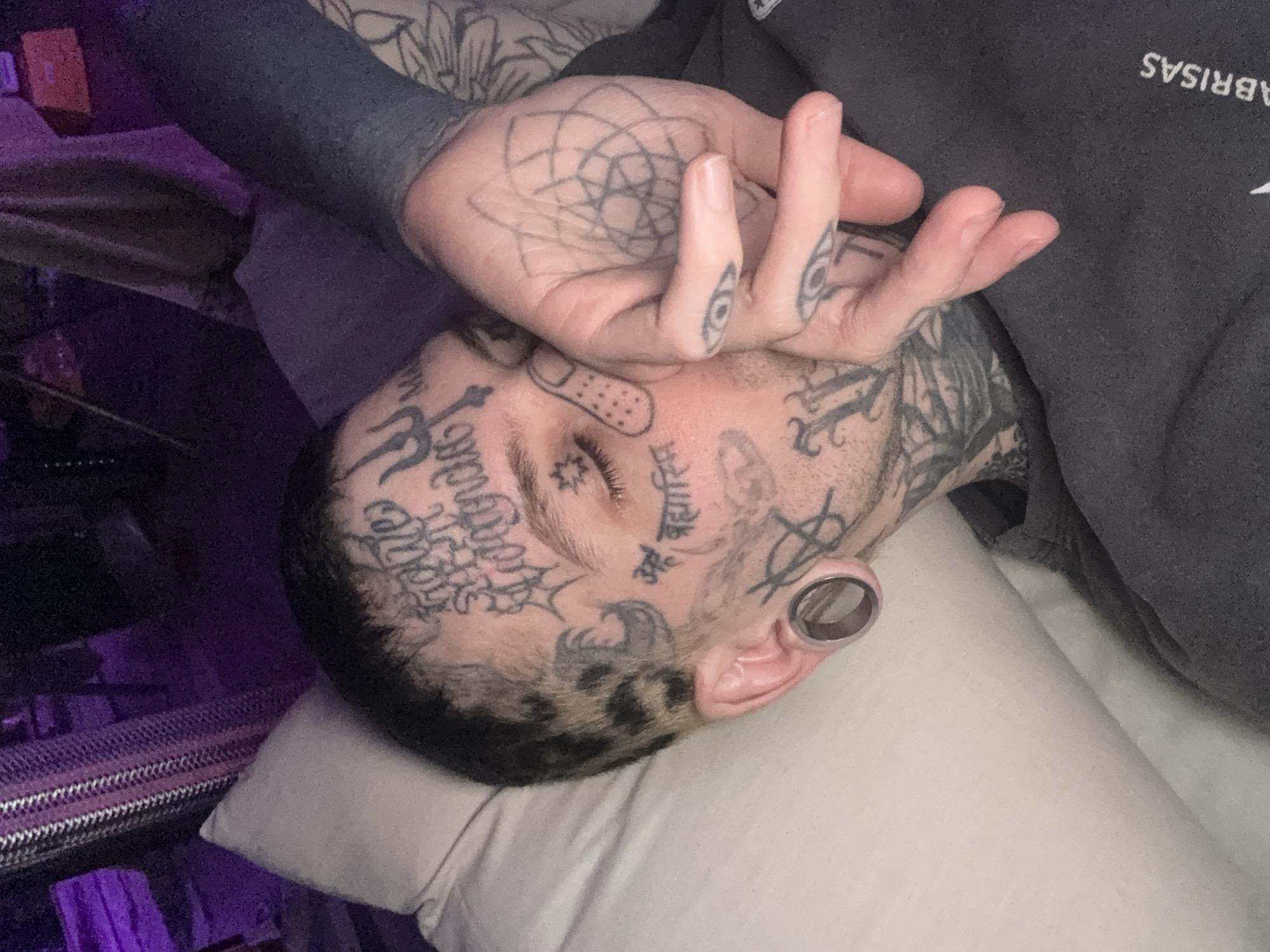 Injured tattooed man rests indoors in Buenos Aires