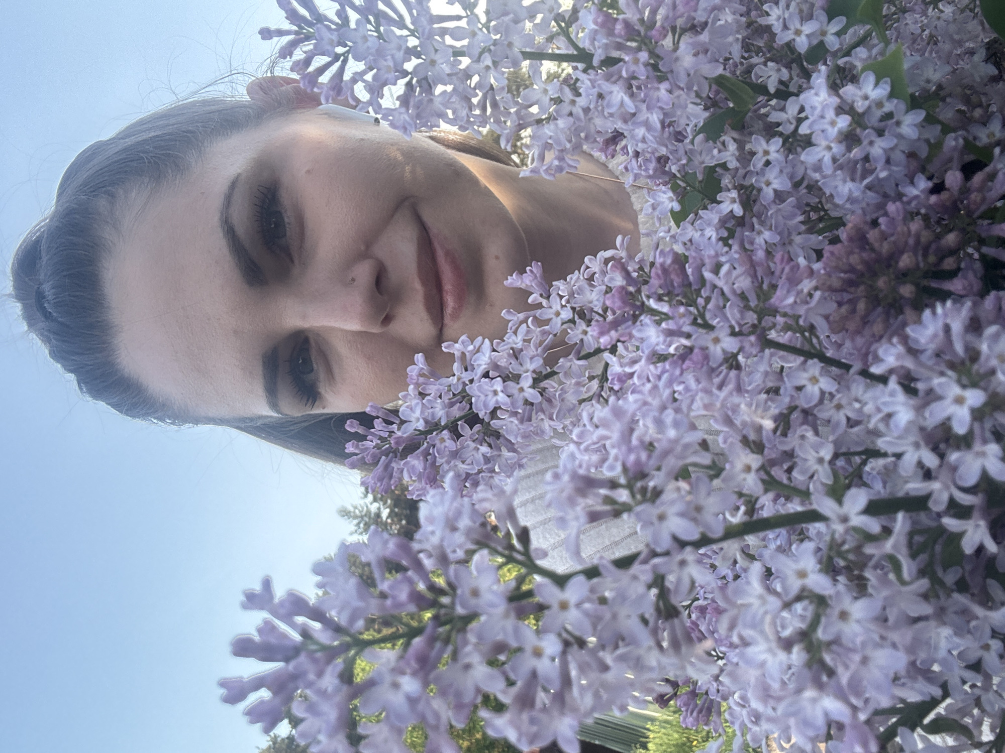 Woman poses with blooming lilacs in Раздолье, Russia