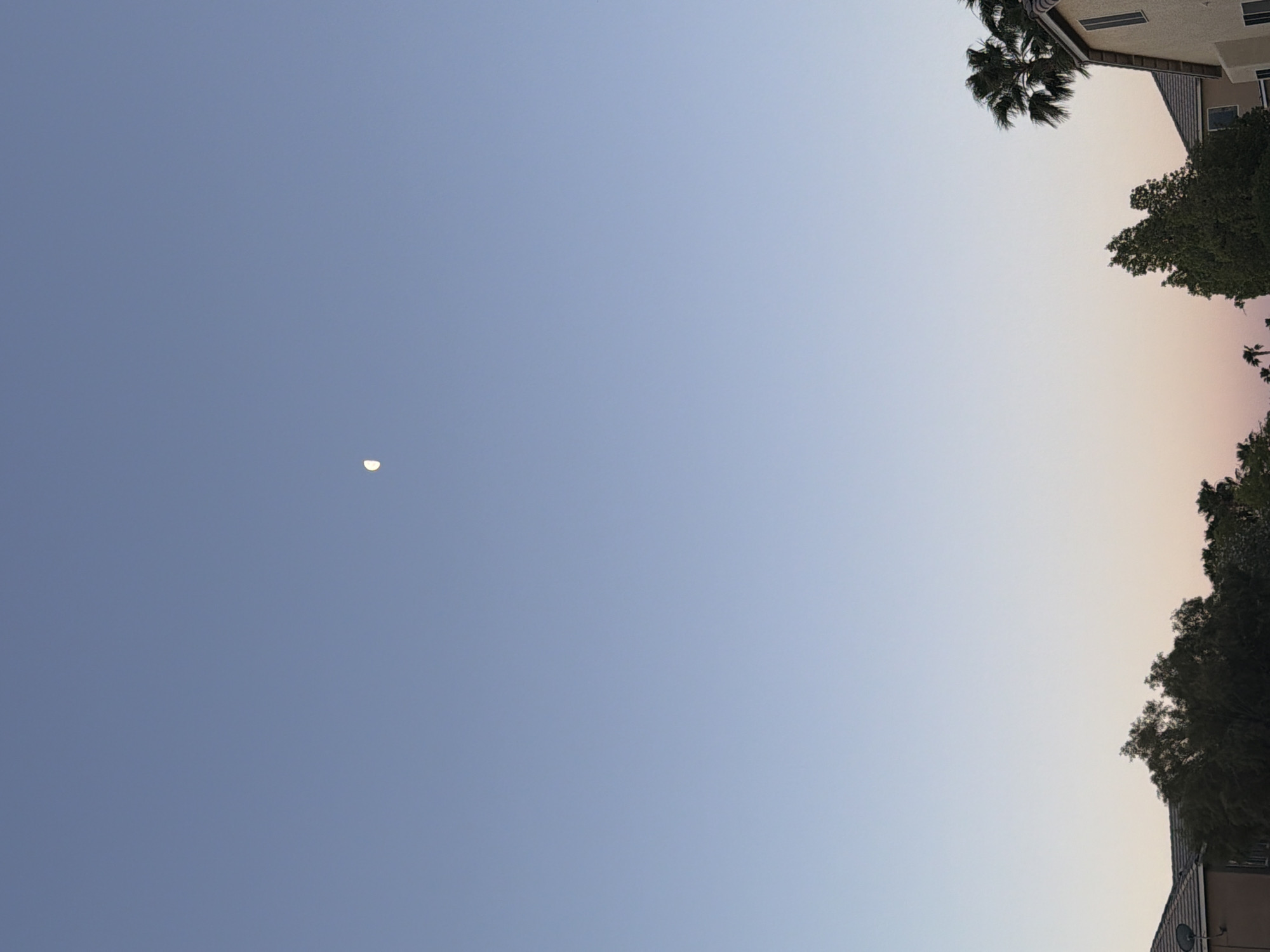 Crescent moon visible during daylight sky gradient in Las Vegas