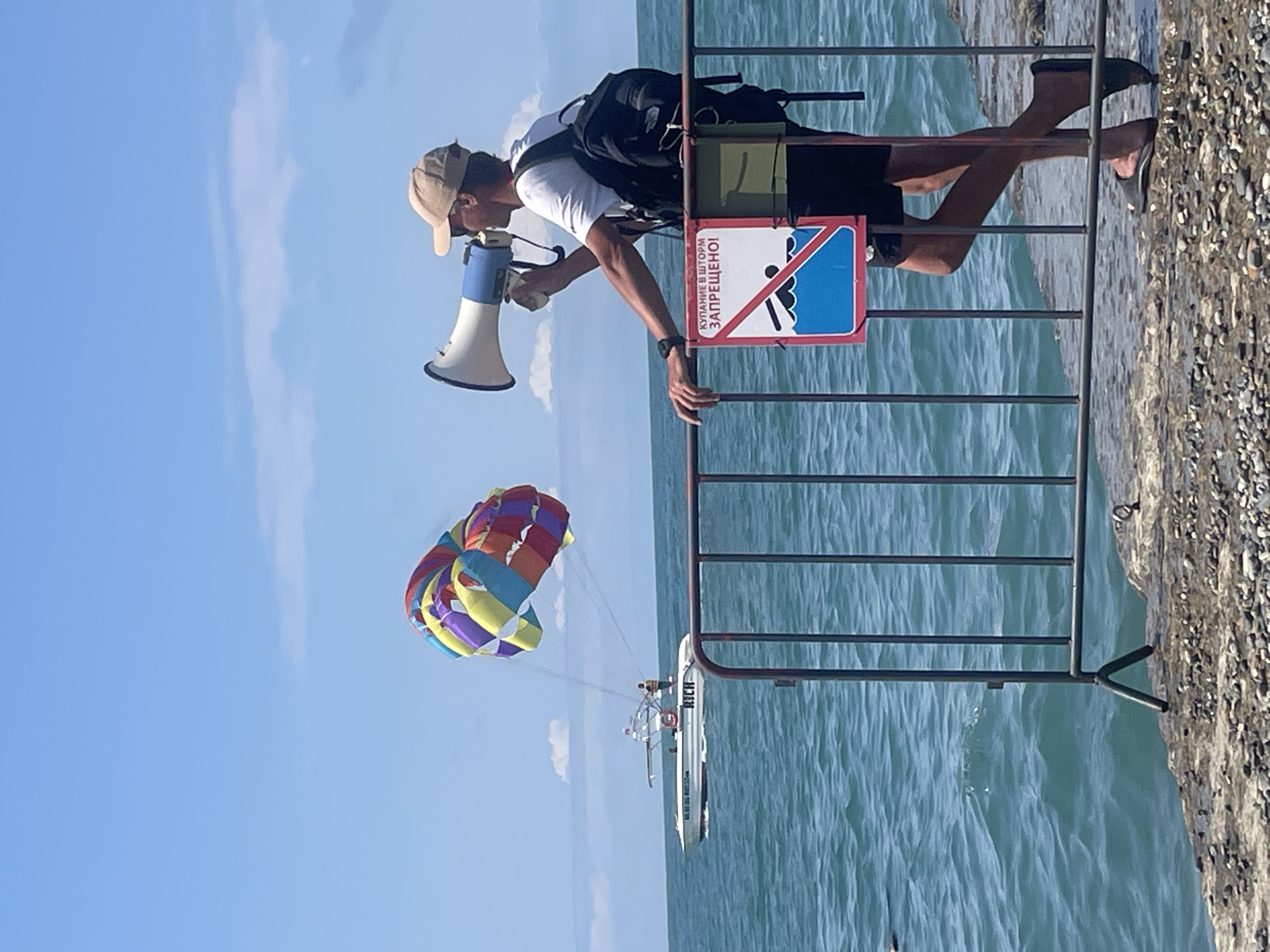 Crowded Sochi beach scene with megaphone address from pier