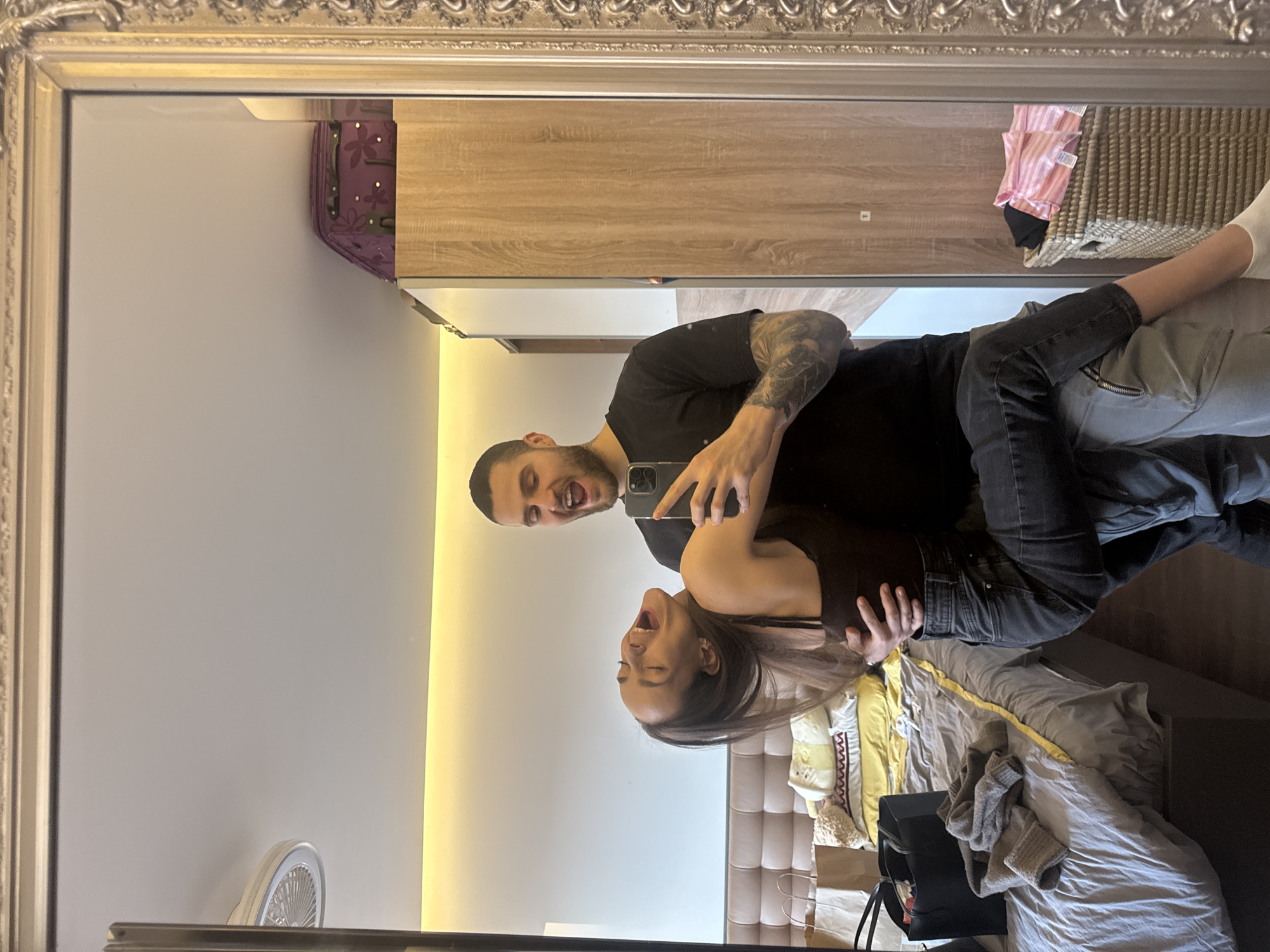 Couple takes selfies with orange phone in Sofia room