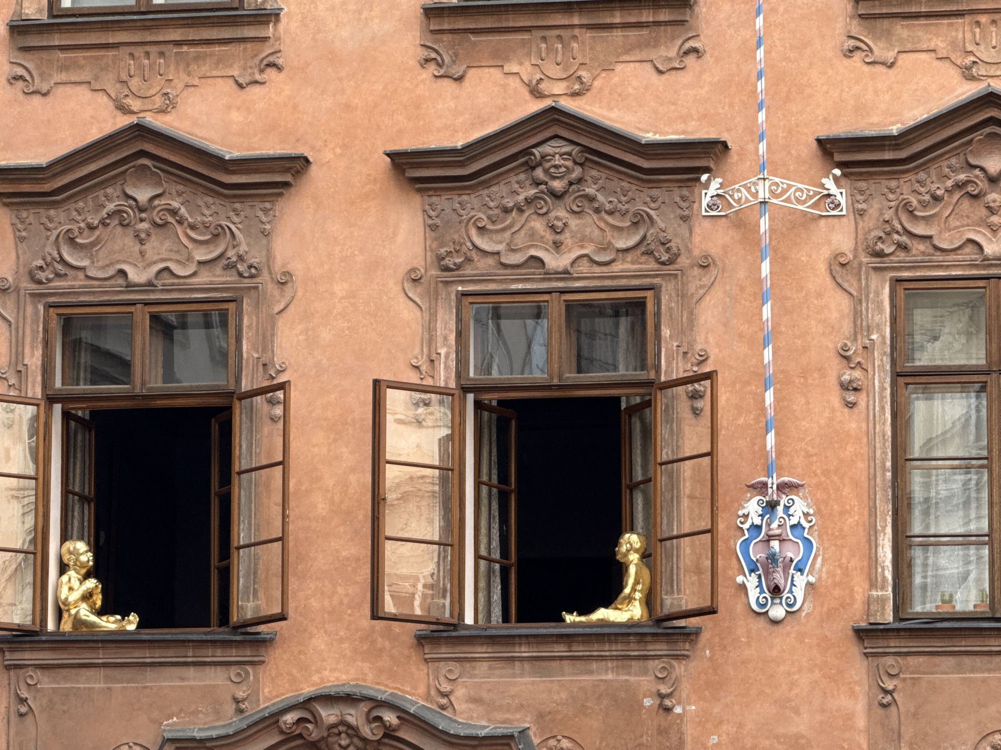 Orange stucco facade with ornate window details in Prague