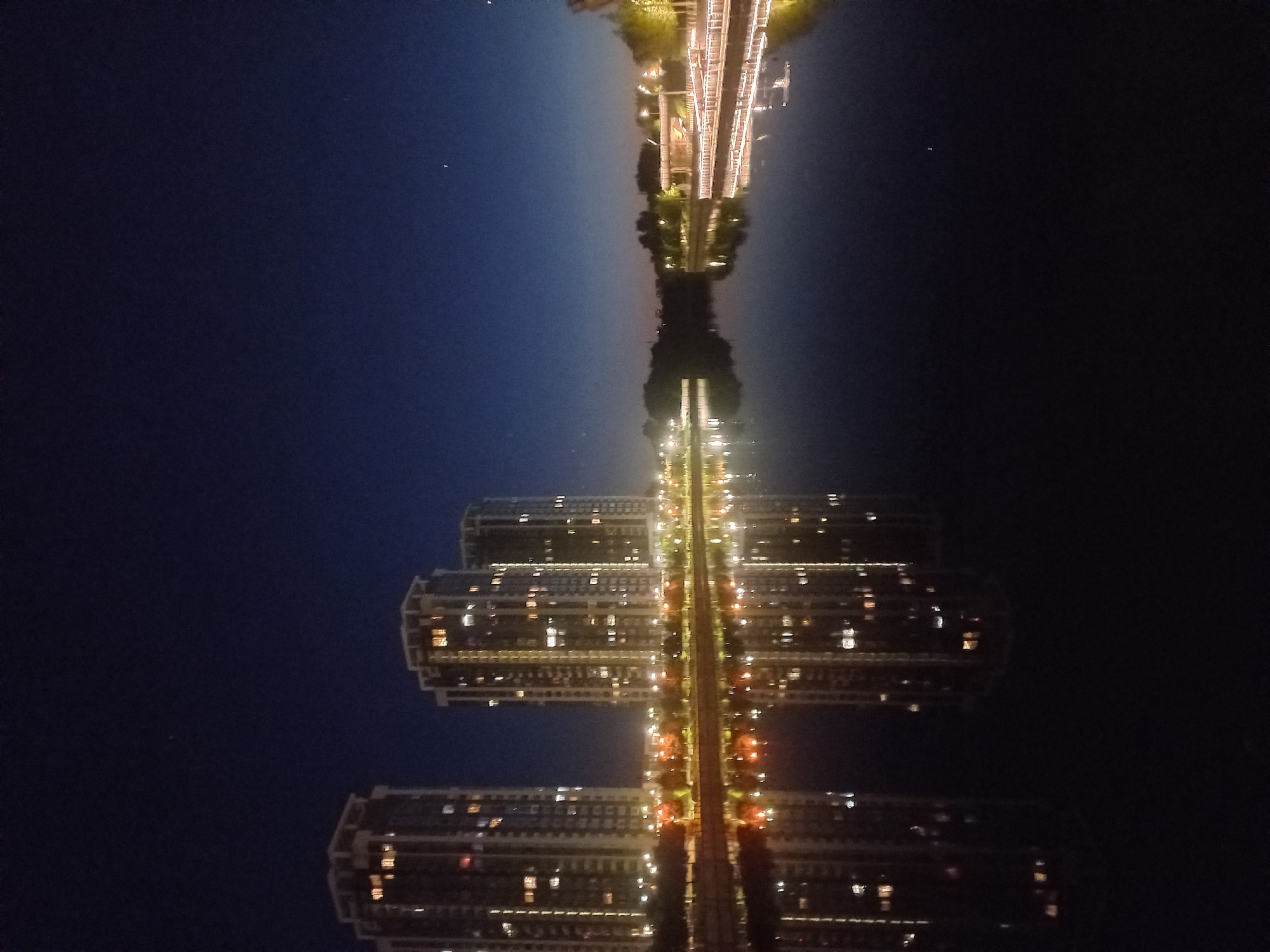 Illuminated buildings reflect in Kyiv waterway at night