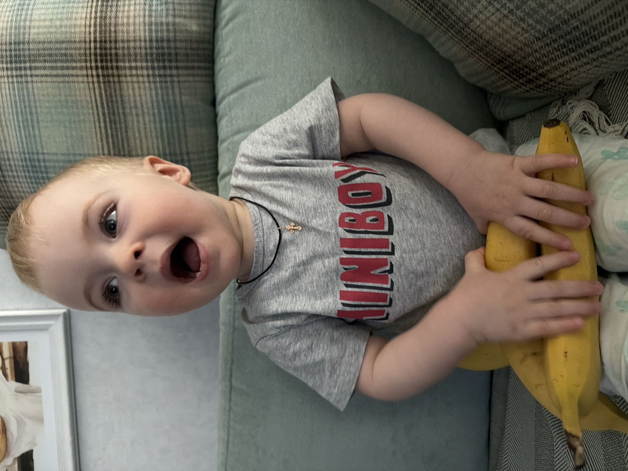 Child plays with bananas while dog rests in Votkinsk home