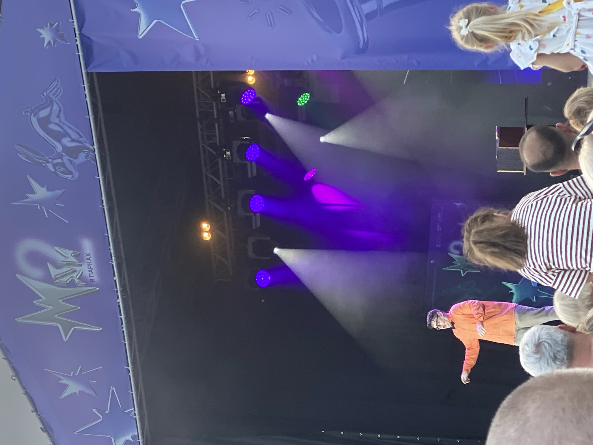 Outdoor concert with branded stage, live performers, and beachside setting