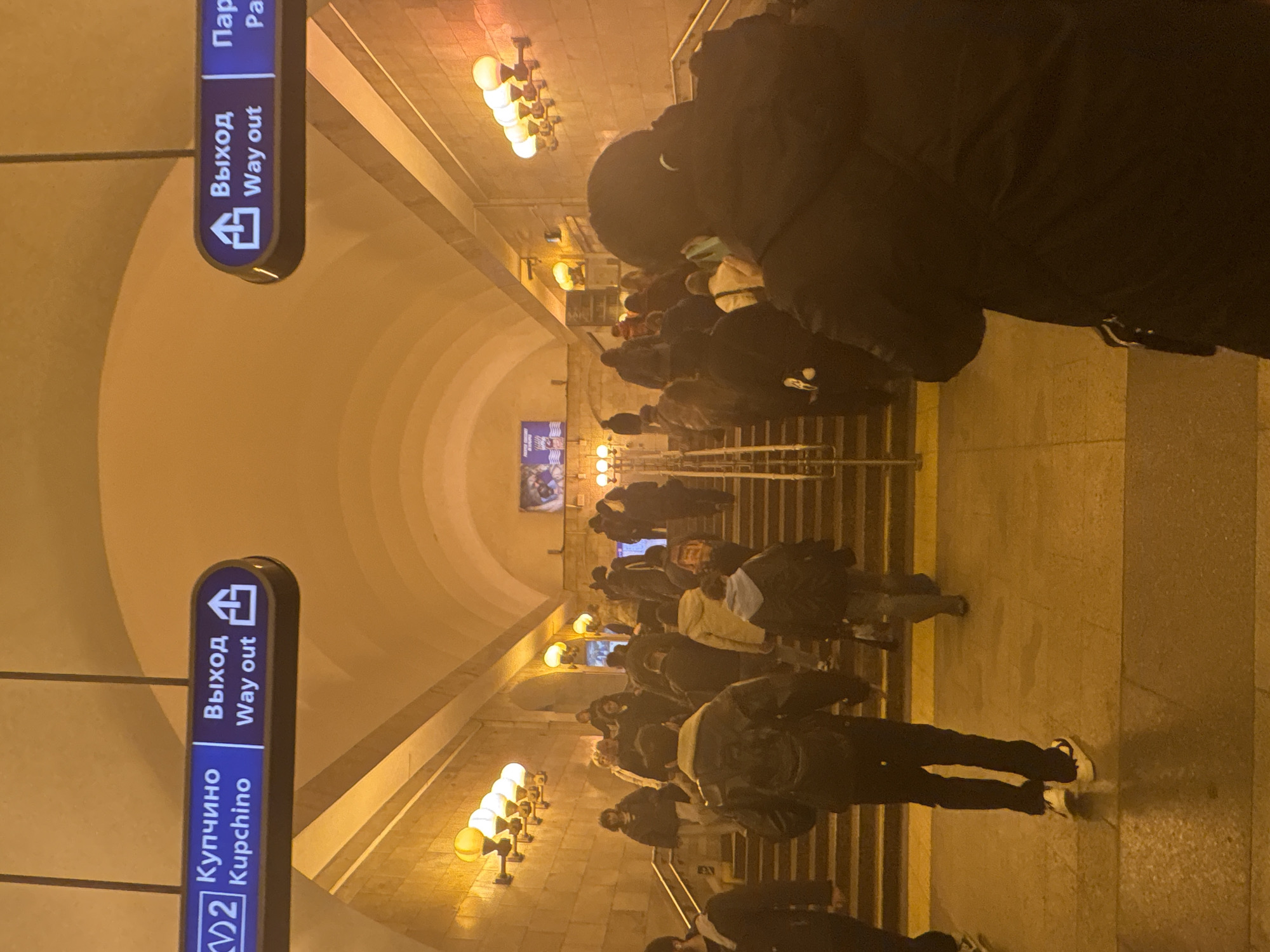 Evening commuters navigate Saint Petersburg metro station escalators