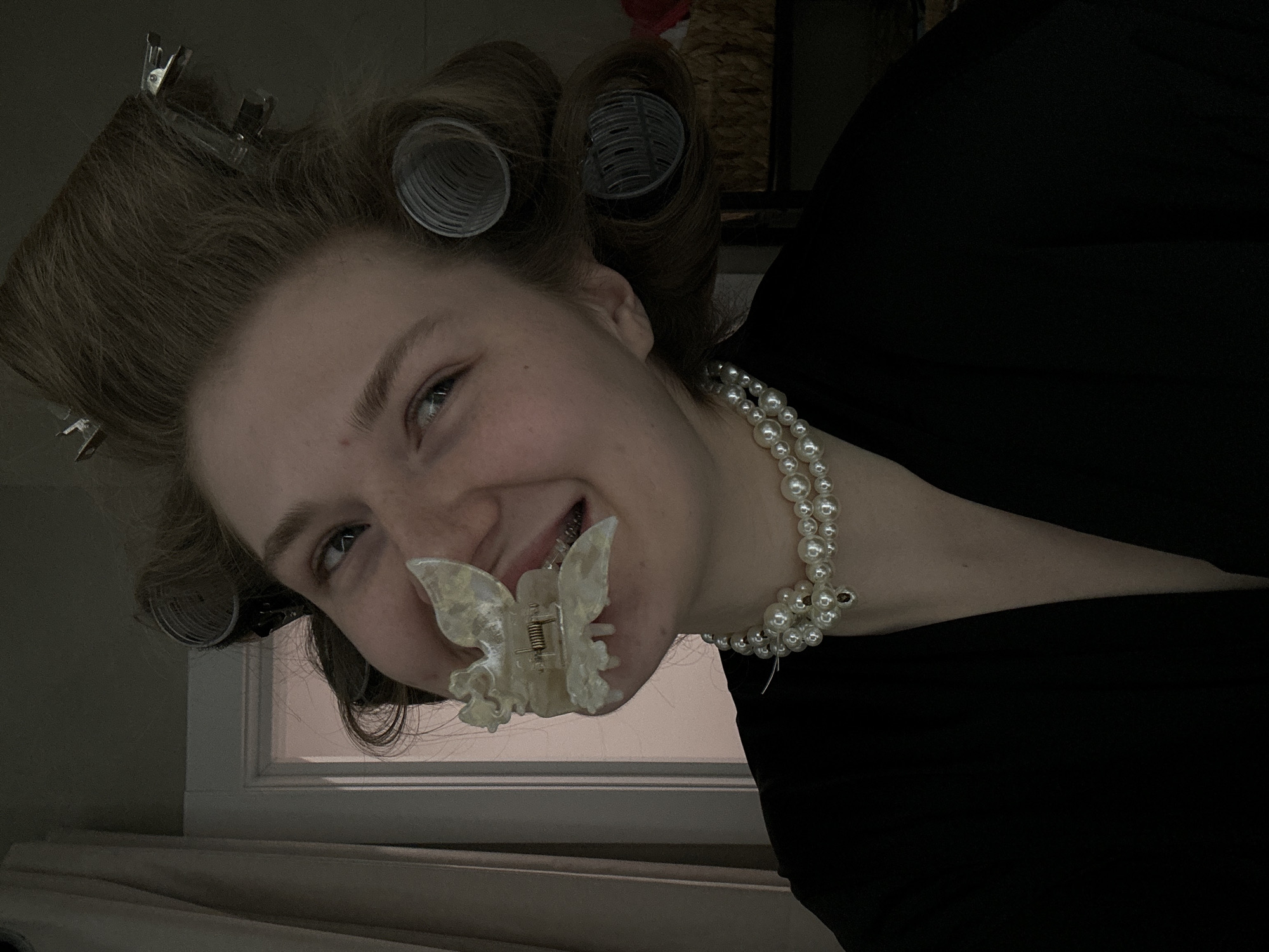 Woman in hair rollers and pearls photographed indoors in Kazan