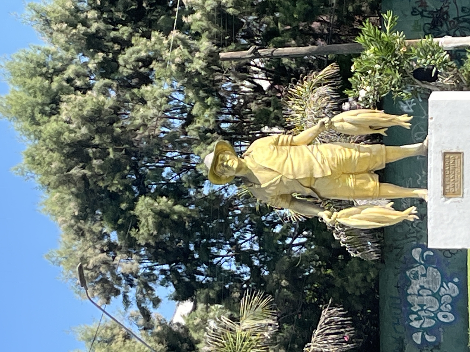 Golden fish-holding statue observed on green pedestal