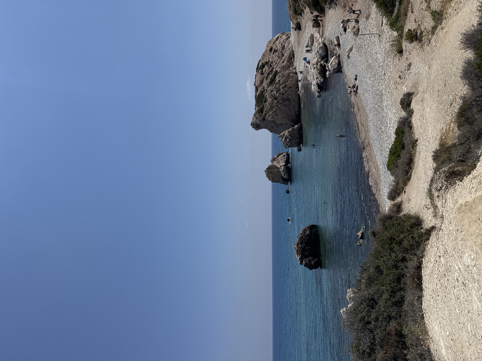 Tourists climb iconic Aphrodite's Rock in Cyprus under clear skies
