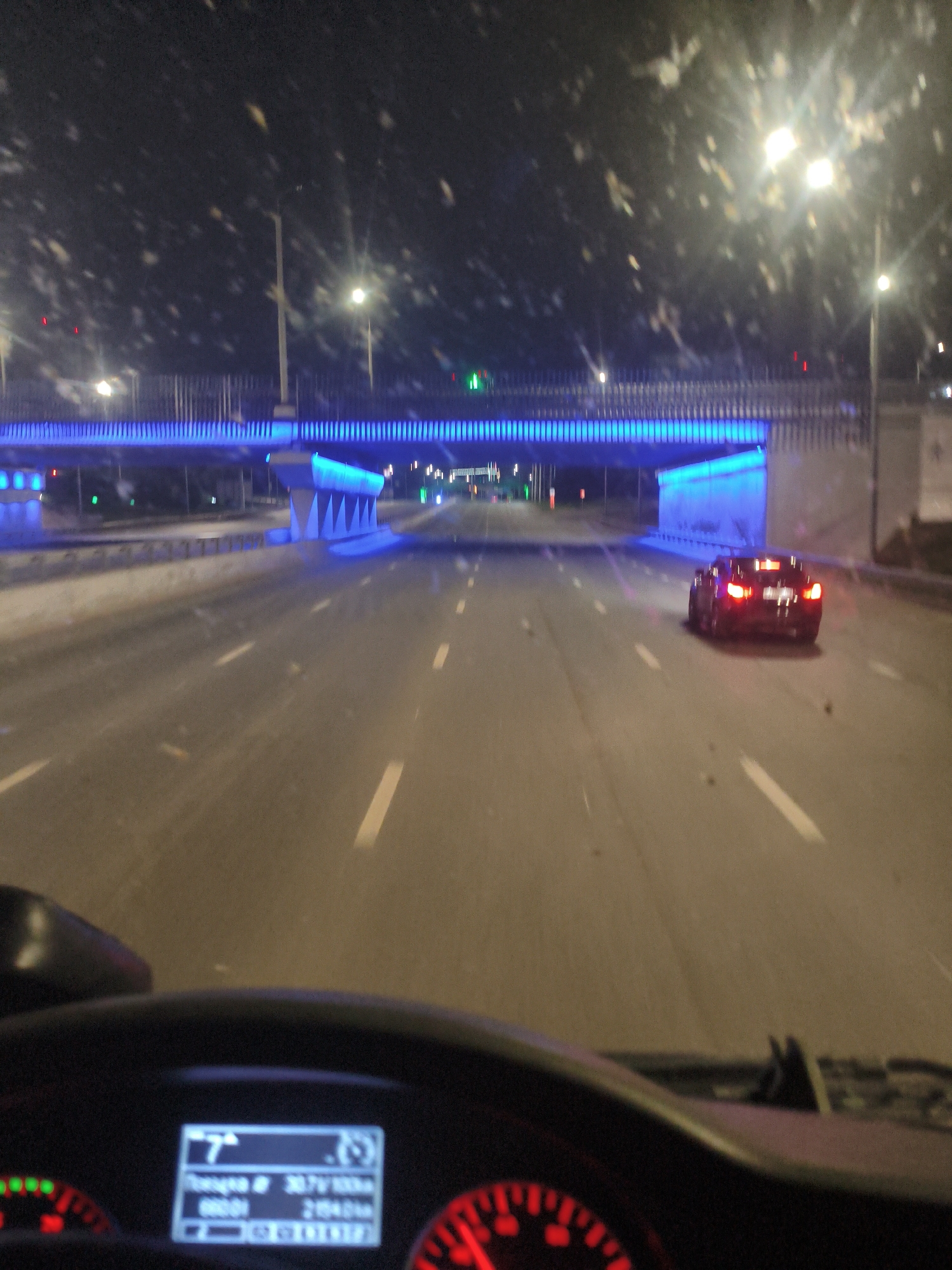 Wet highway night drive under a glowing overpass in Ufa