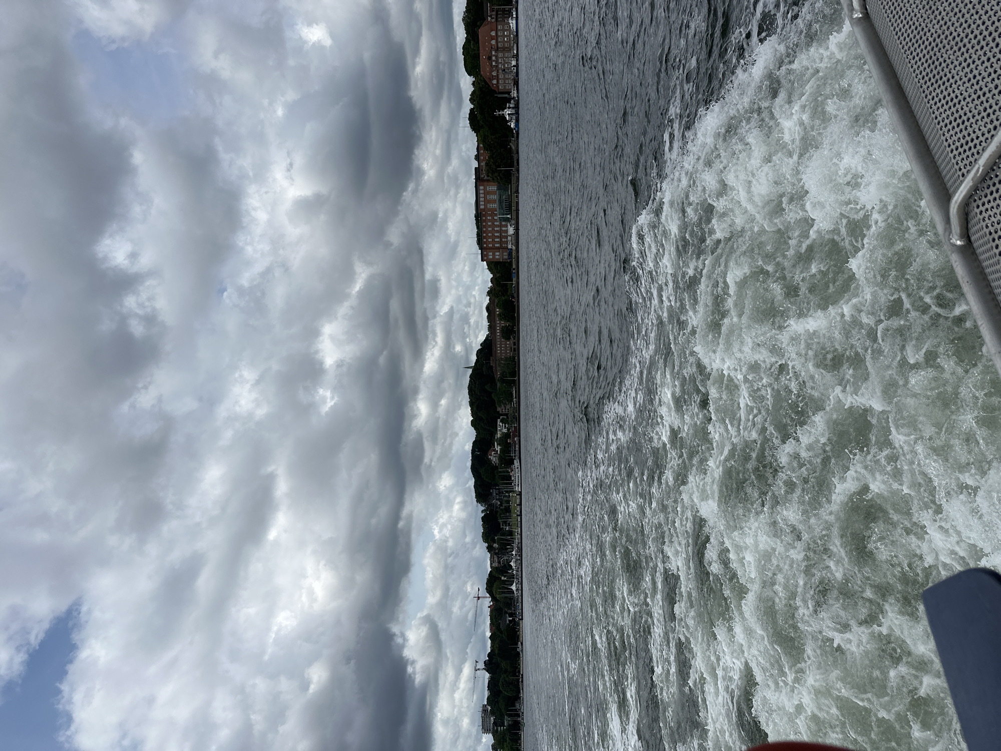 Out on Kiel Fjord, city skyline receding behind a moving boat