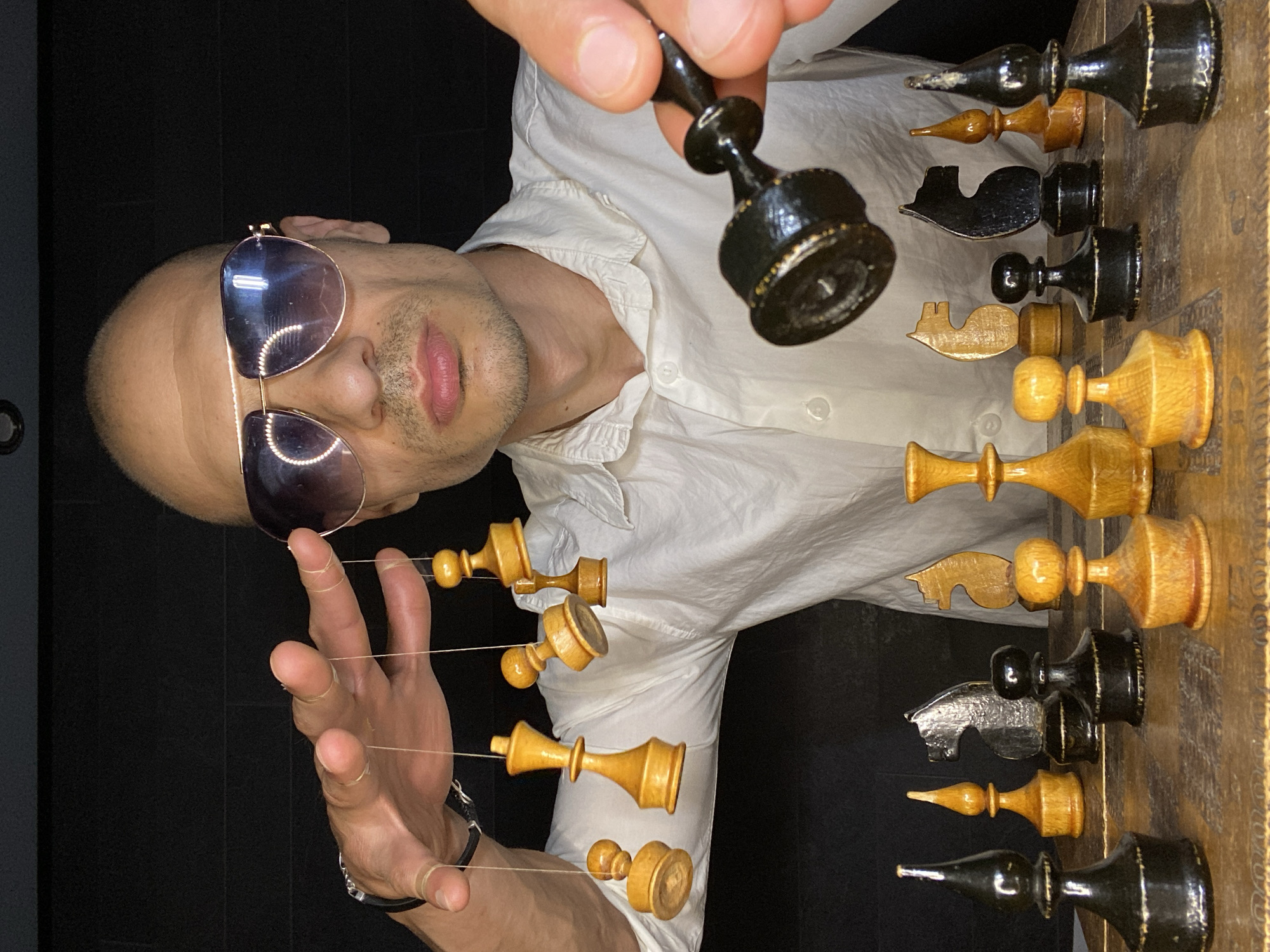 Chess pieces held and suspended in a dark Pleven room