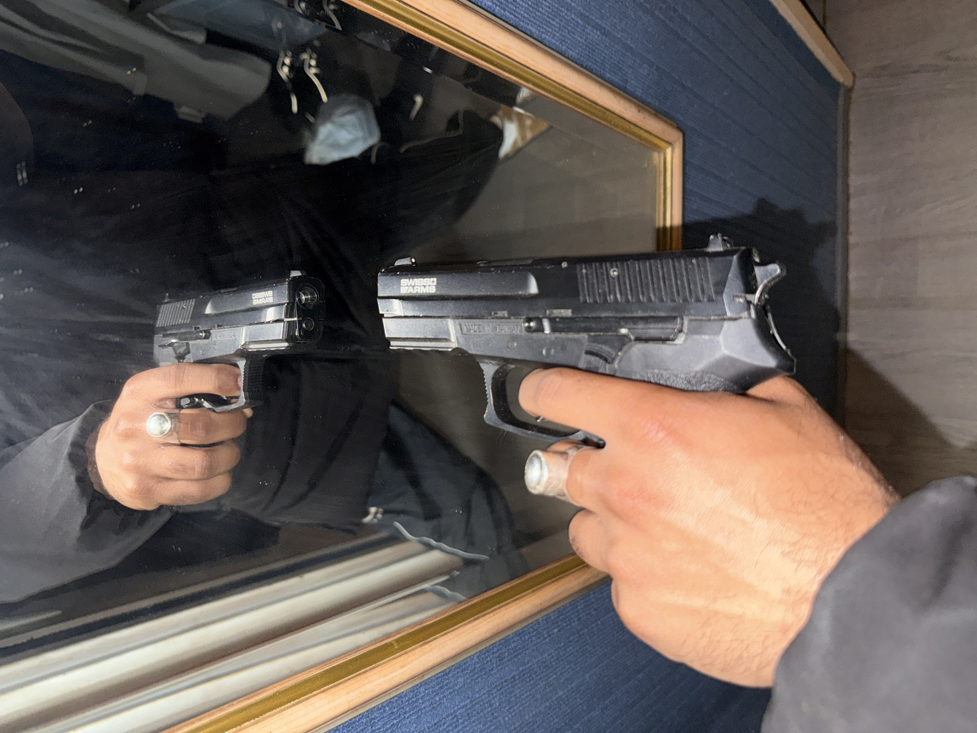 Person photographed holding Swiss Arms pistol in Domont mirror