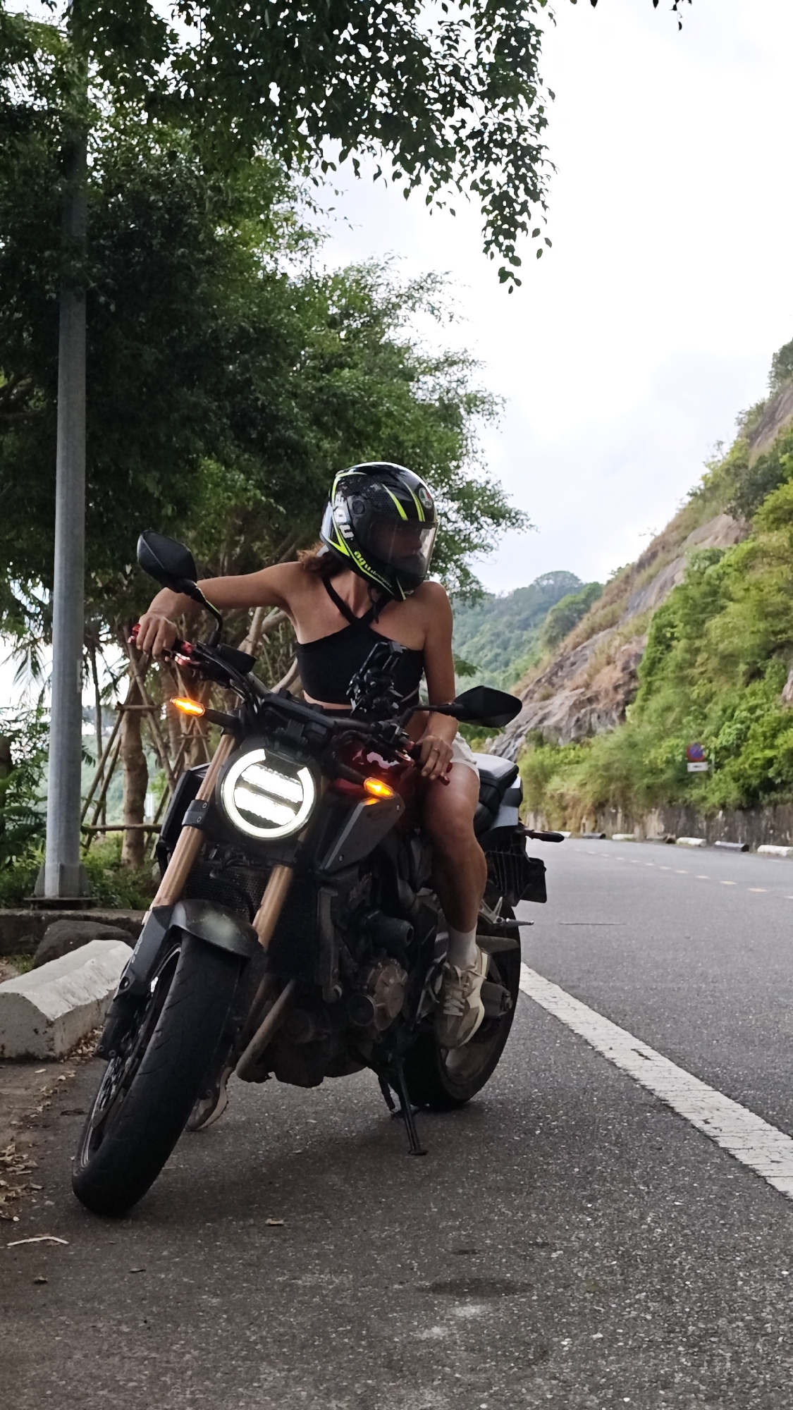Motorcyclist pauses along coastal road in Đà Nẵng, Vietnam