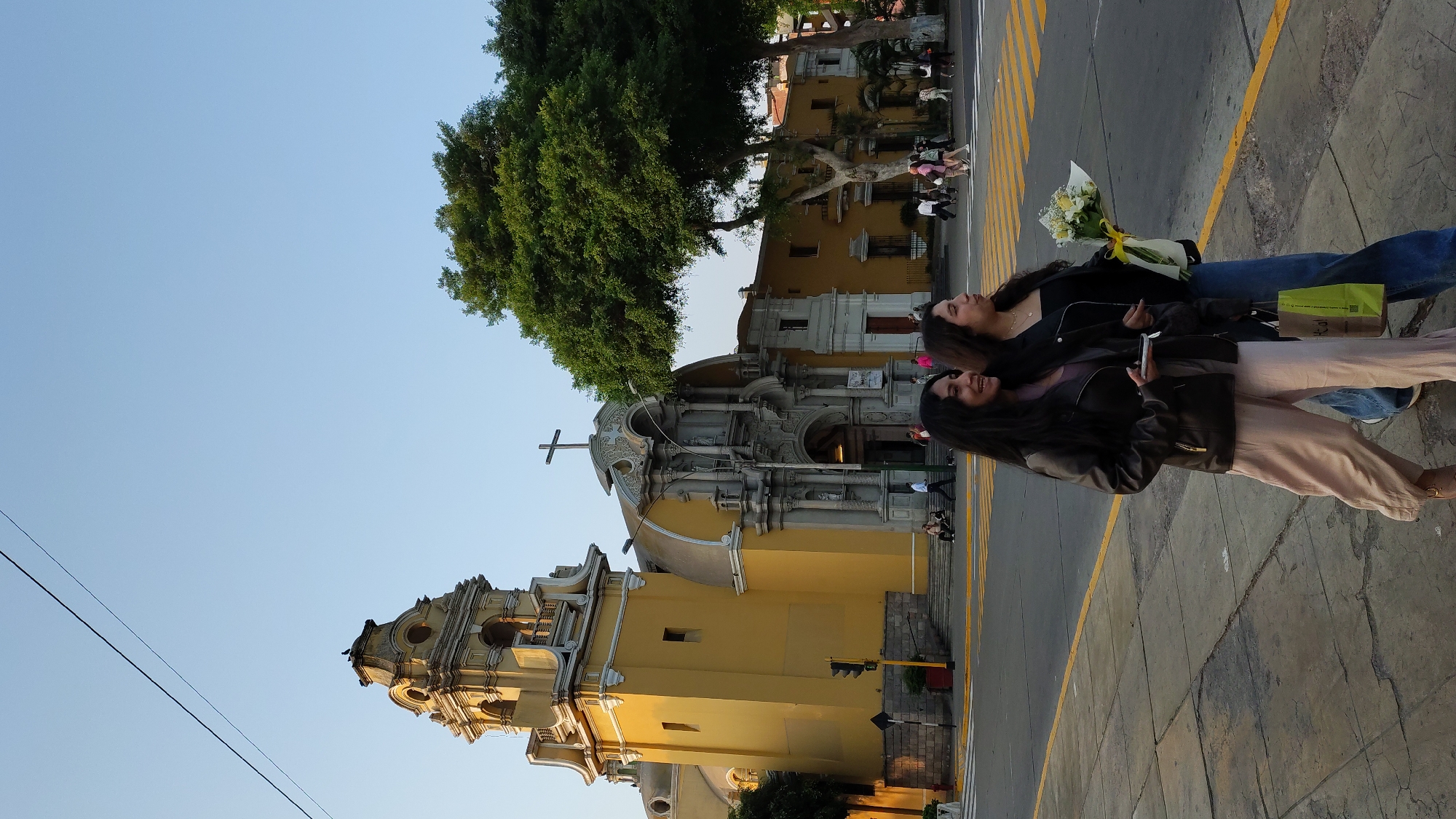 Two women photographed on Barranco sidewalk under clear skies