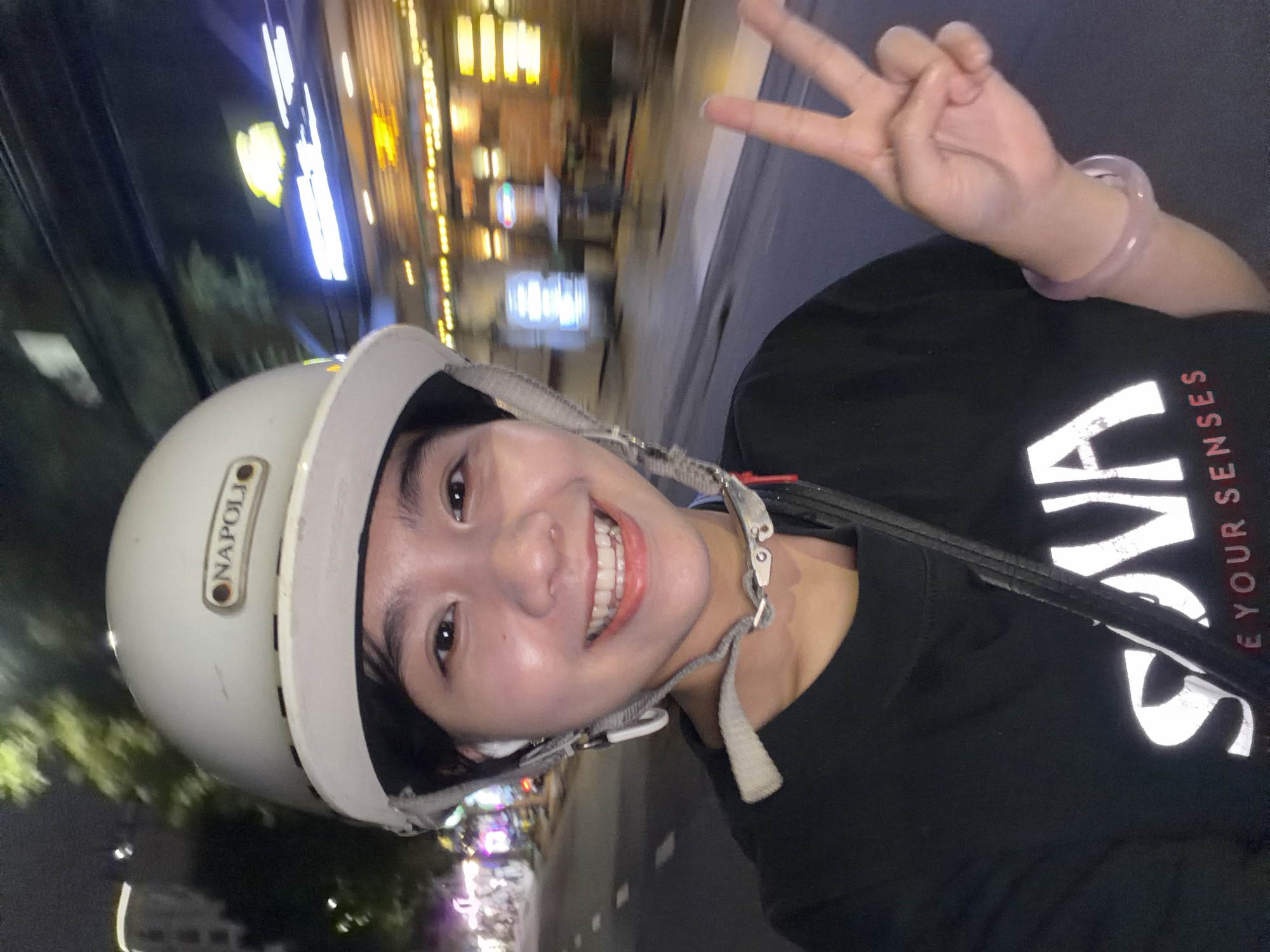 Motorcyclist makes peace sign during nighttime ride in Đà Nẵng