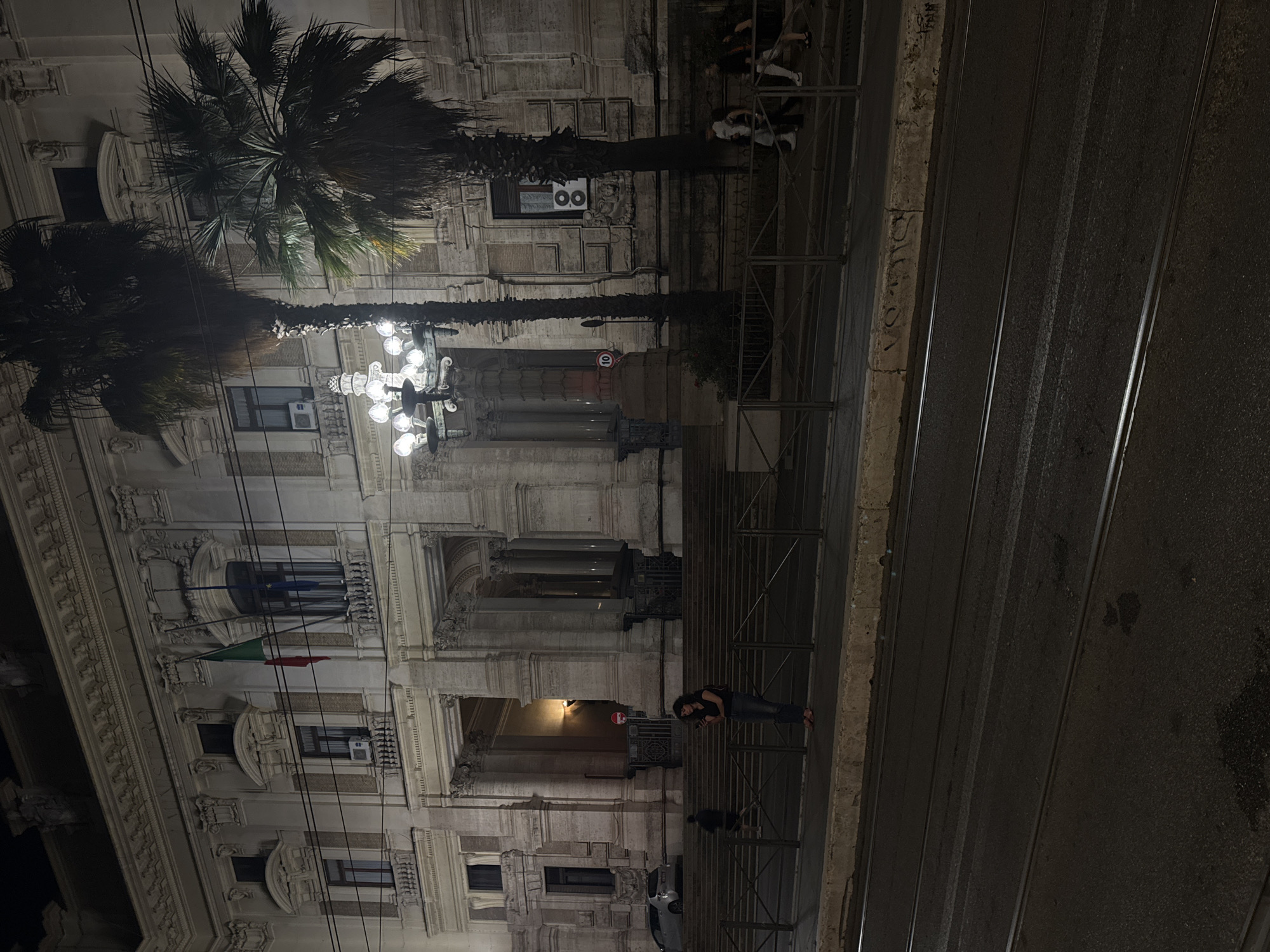 Classical Roman building with Italian flag photographed at night